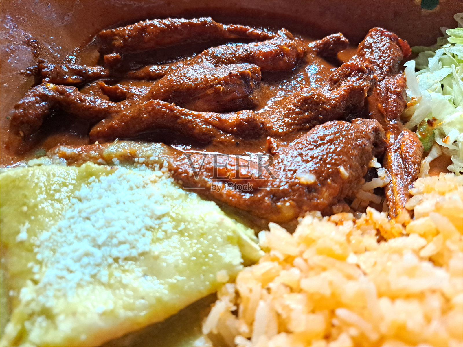 用红汁青蛙腿配米饭和沙拉制成的菜,被认为是烹饪的特色菜照片摄影图片