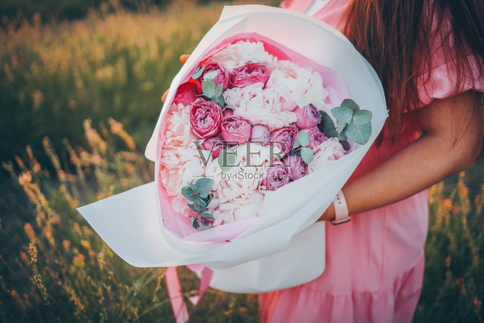 一个捧着一大束牡丹的女孩在大自然中照片摄影图片