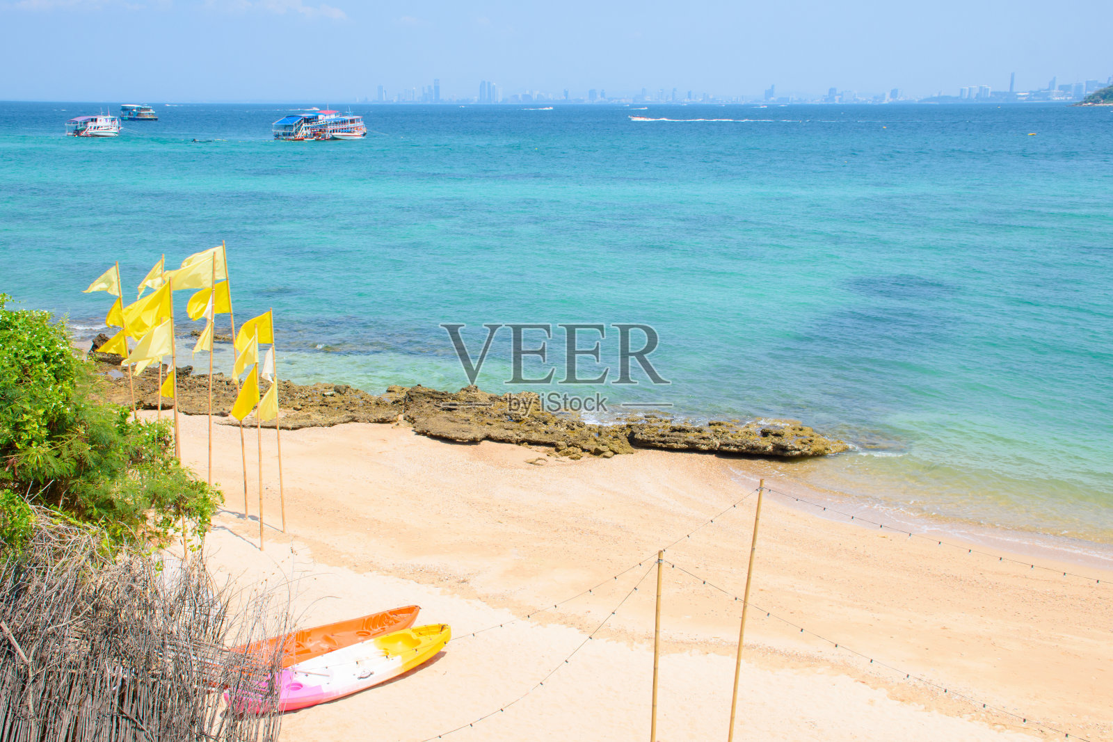 俯瞰美丽的热带海滩和清澈的蓝色海水,皮划艇和旗帜在高兰岛的海滩度假。令人惊叹的海景和海滩,装饰着暑假的主题。照片摄影图片