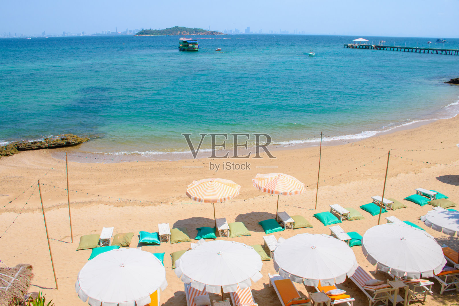 Ariel俯瞰美丽的热带海滩和蓝色的海水,放松区椅子,沙滩上的躺椅和雨伞。芭堤雅兰恩岛的热门旅游景点。照片摄影图片