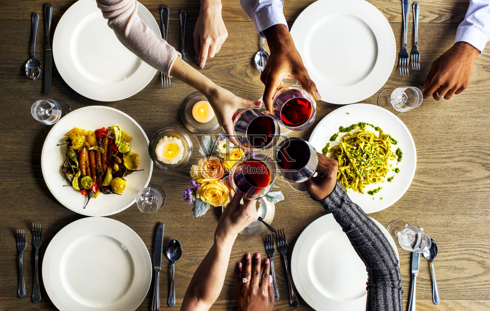 人们在餐厅里把酒杯抱在一起照片摄影图片