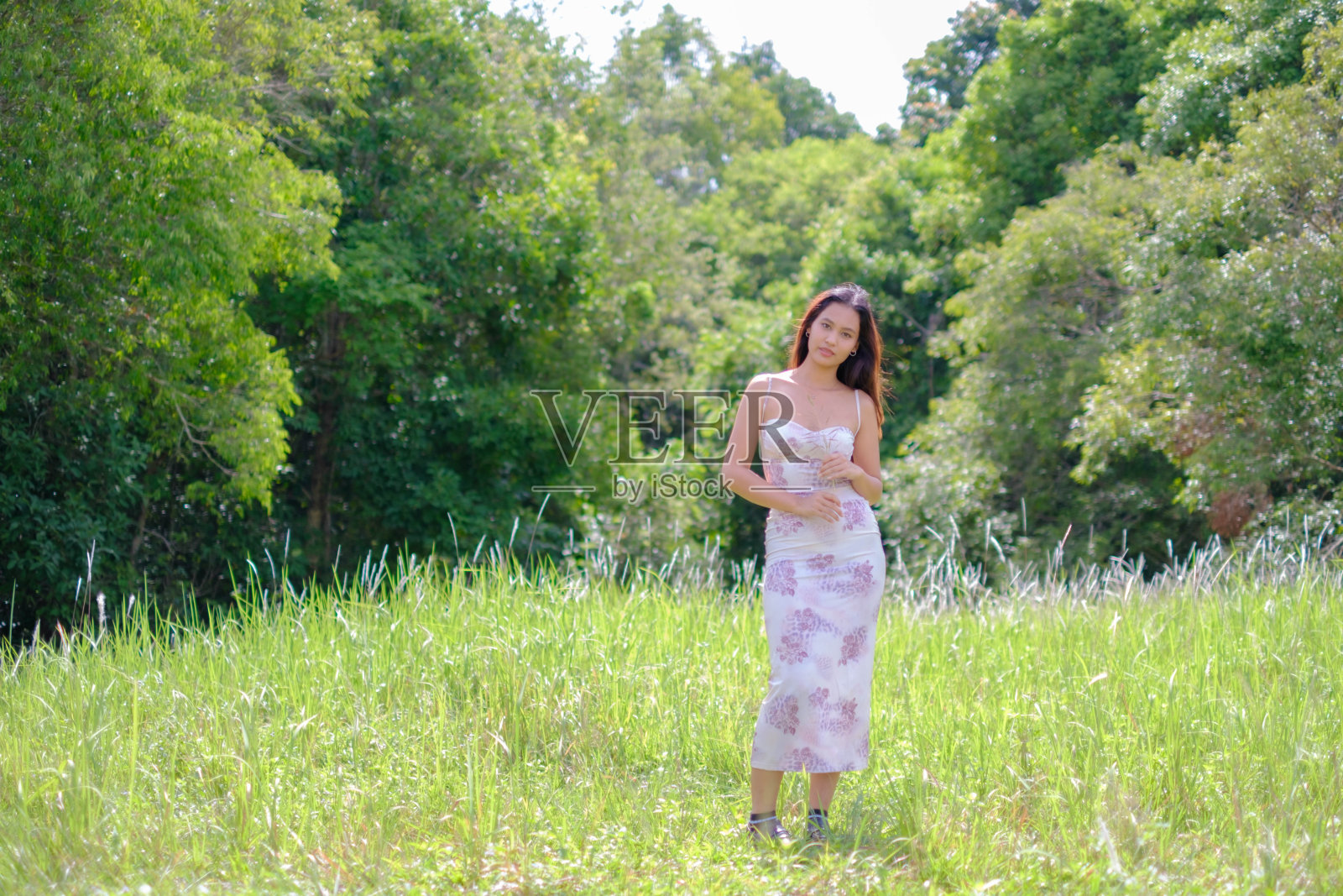 一位年轻的亚洲女子走在花丛中。照片摄影图片