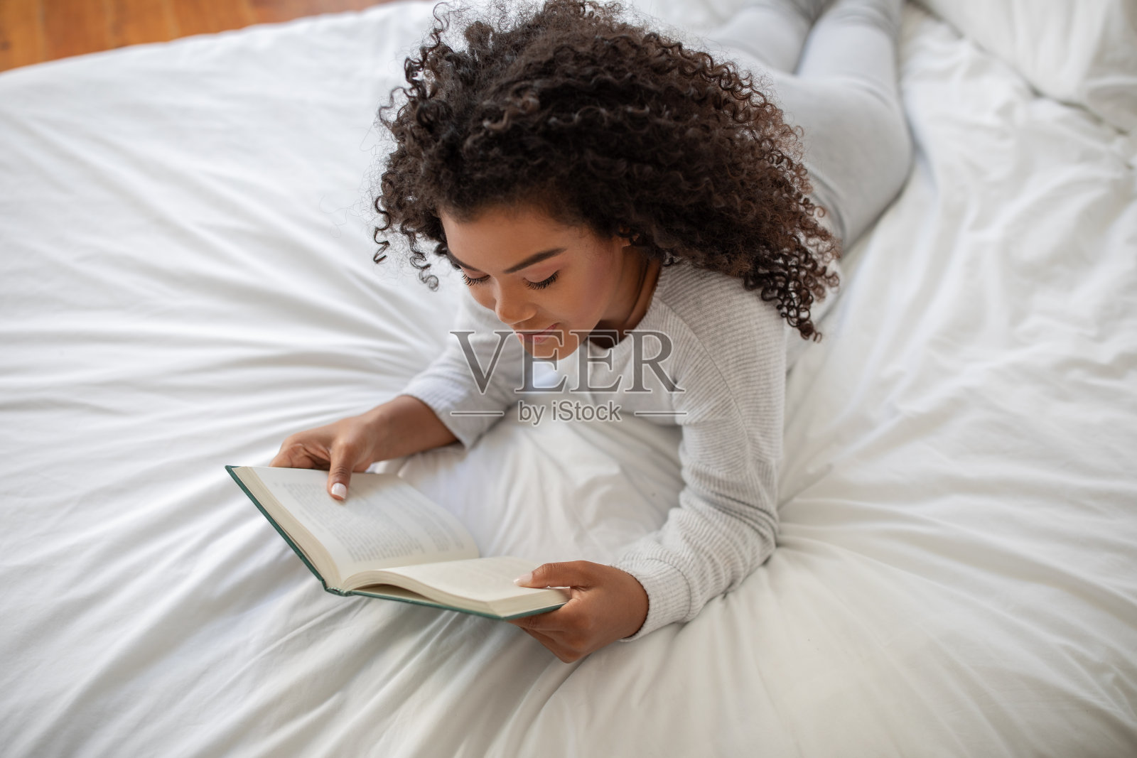 躺在床上看书的女人照片摄影图片