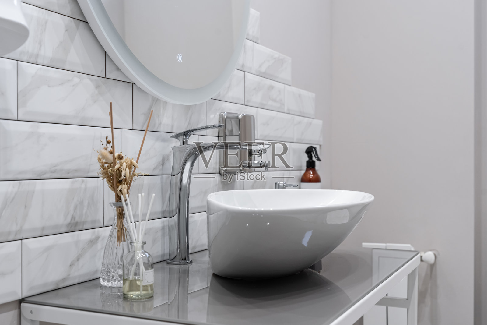 现代的浴室设计,浅色的瓷砖,白色的家具和白色的马桶。浴室的镜子照片摄影图片