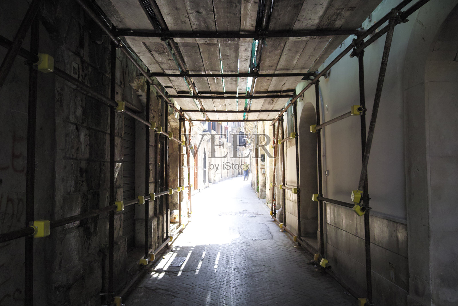 上层建筑有脚手架的小巷照片摄影图片