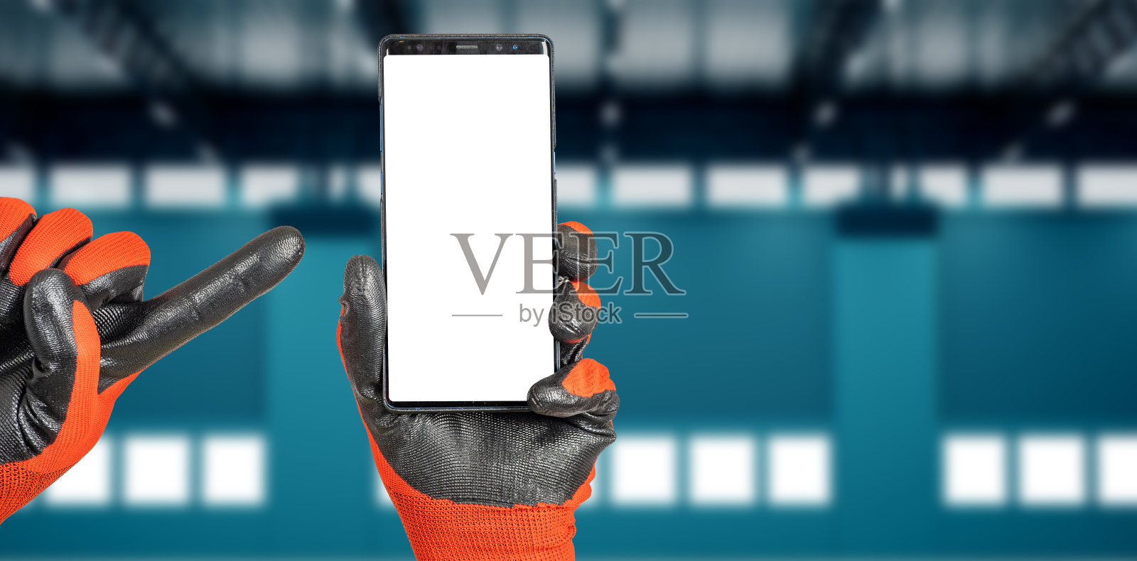 手指着手机。手指着手机。手中的手机。双手戴着工作手套,比喻建筑工人。生成器指向显示。地方建设应用程序。网站寻找工头。照片摄影图片