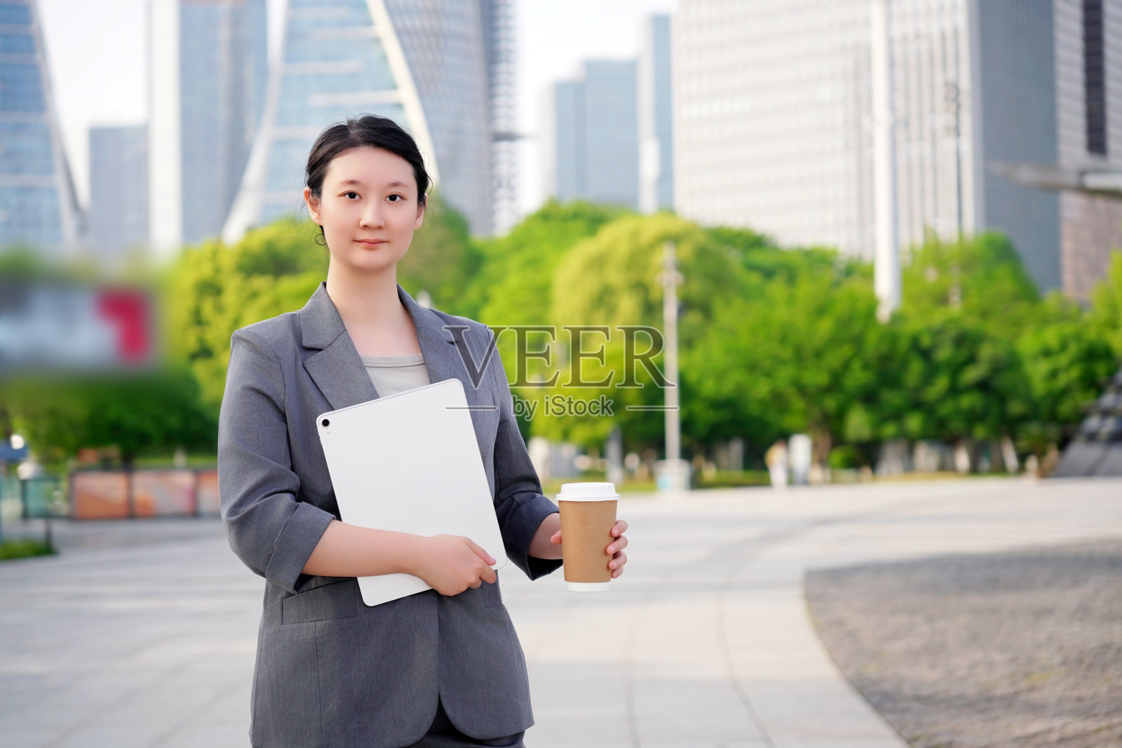在城里拿着平板电脑和咖啡的职业女性照片摄影图片