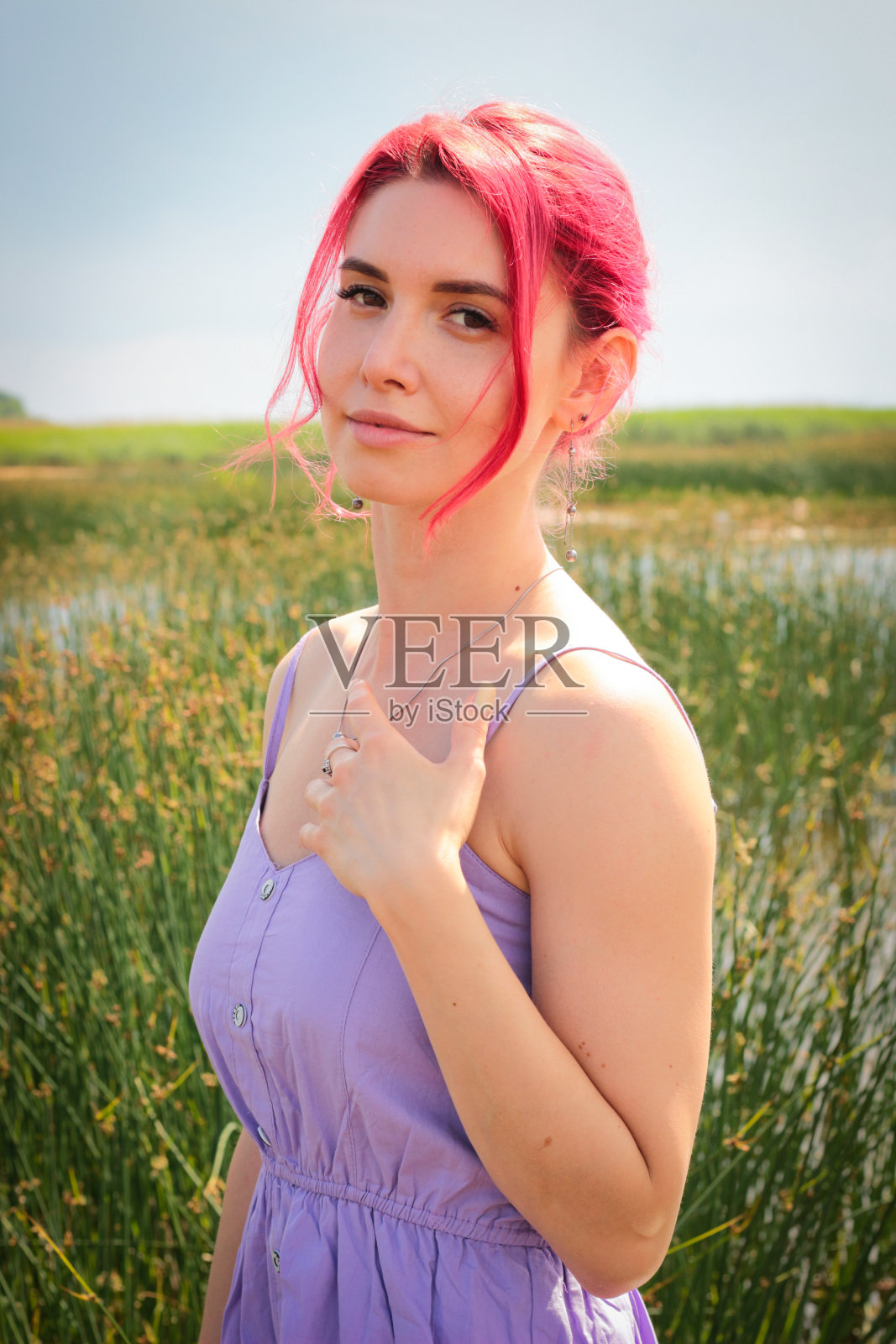 穿着裙子的漂亮女孩在水中以自然为背景摆姿势。高质量照片照片摄影图片