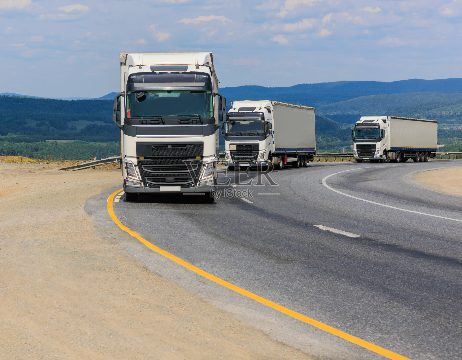 卡车车队沿着乡间小路行驶照片摄影图片