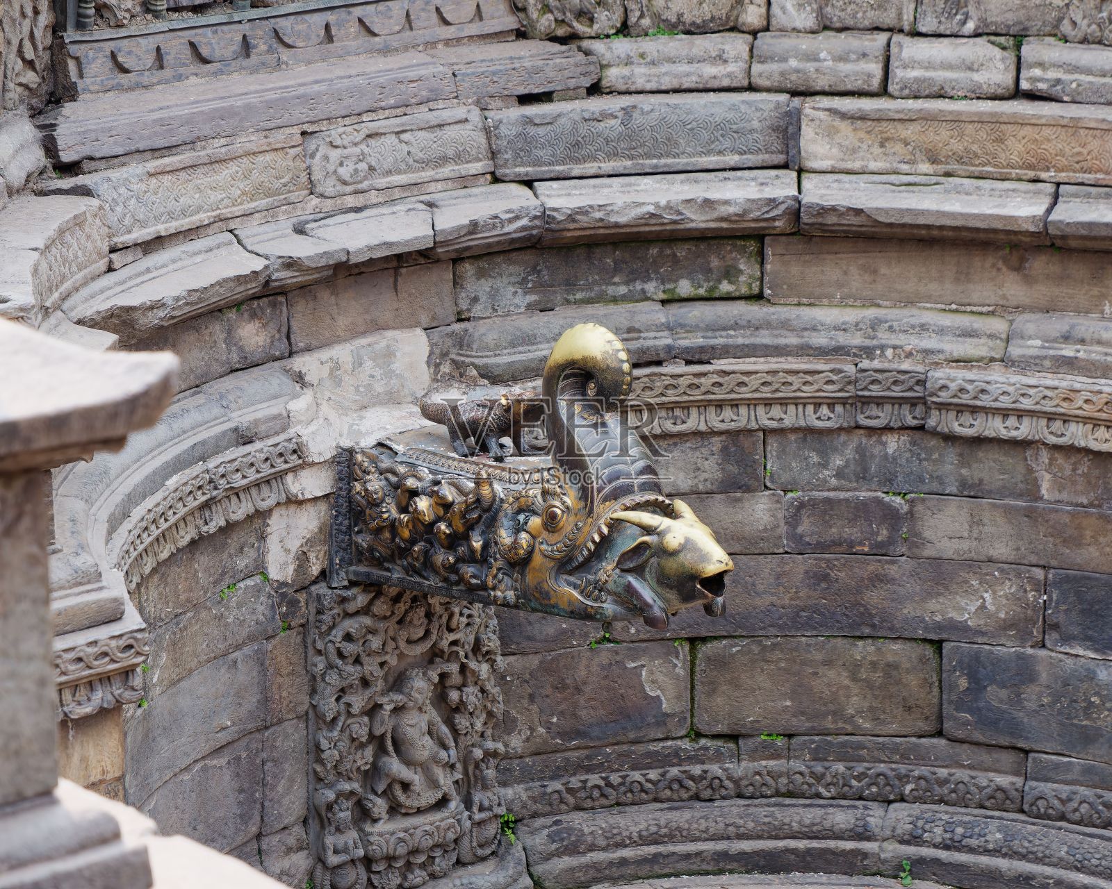 在尼泊尔的帕坦杜巴广场,有着复杂雕刻和金色龙喷口的石头建筑照片摄影图片