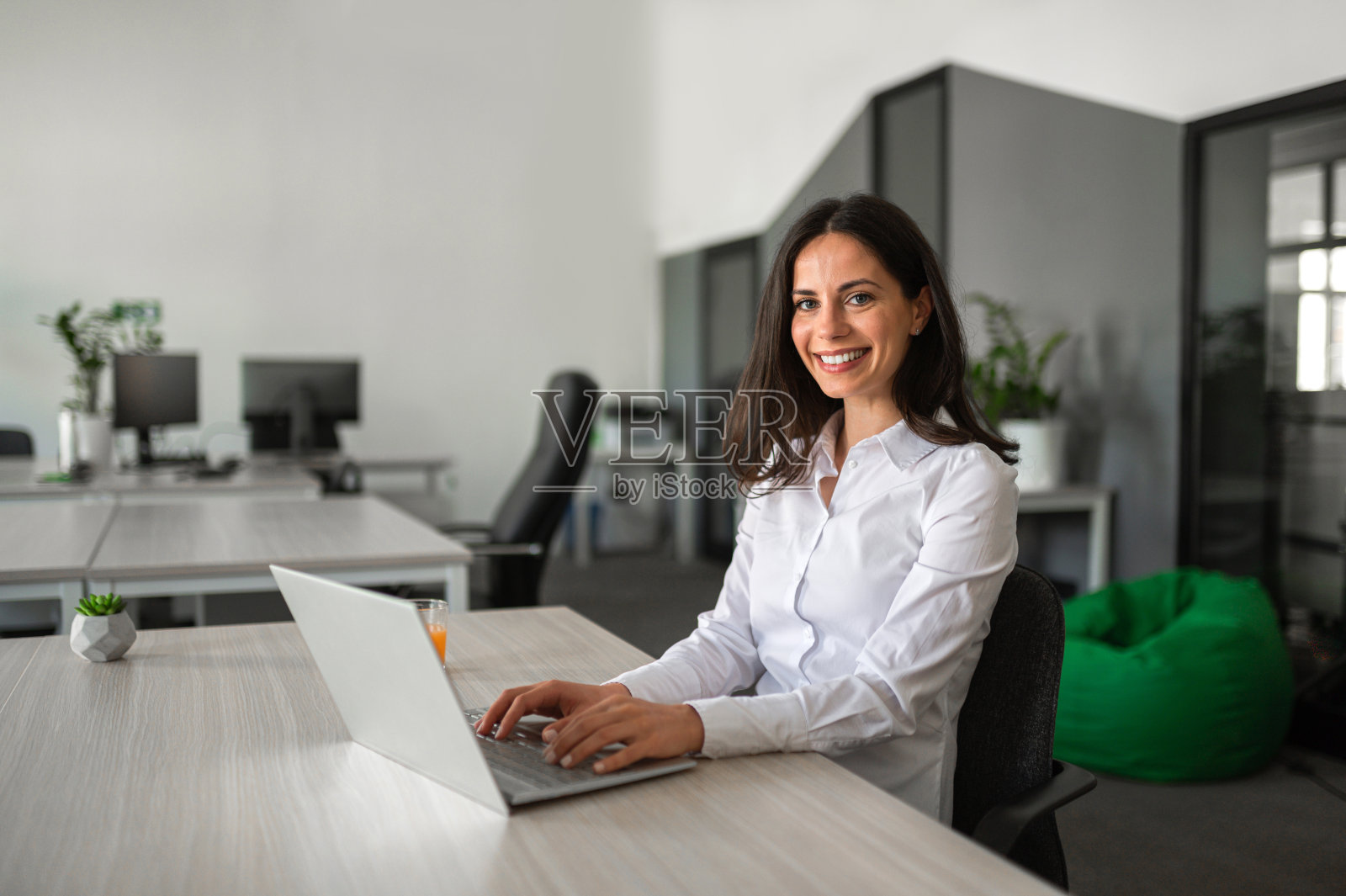 年轻的商务人士微笑着在她的笔记本电脑上工作照片摄影图片