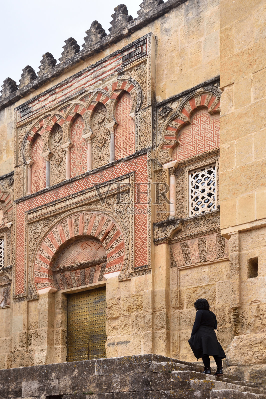 游客在西班牙安达卢西亚科尔多瓦的圣伊尔德丰索门前,大清真寺的摩尔式立面照片摄影图片