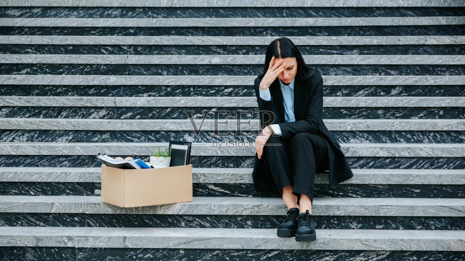 面带忧虑表情坐在户外的白人女性照片摄影图片