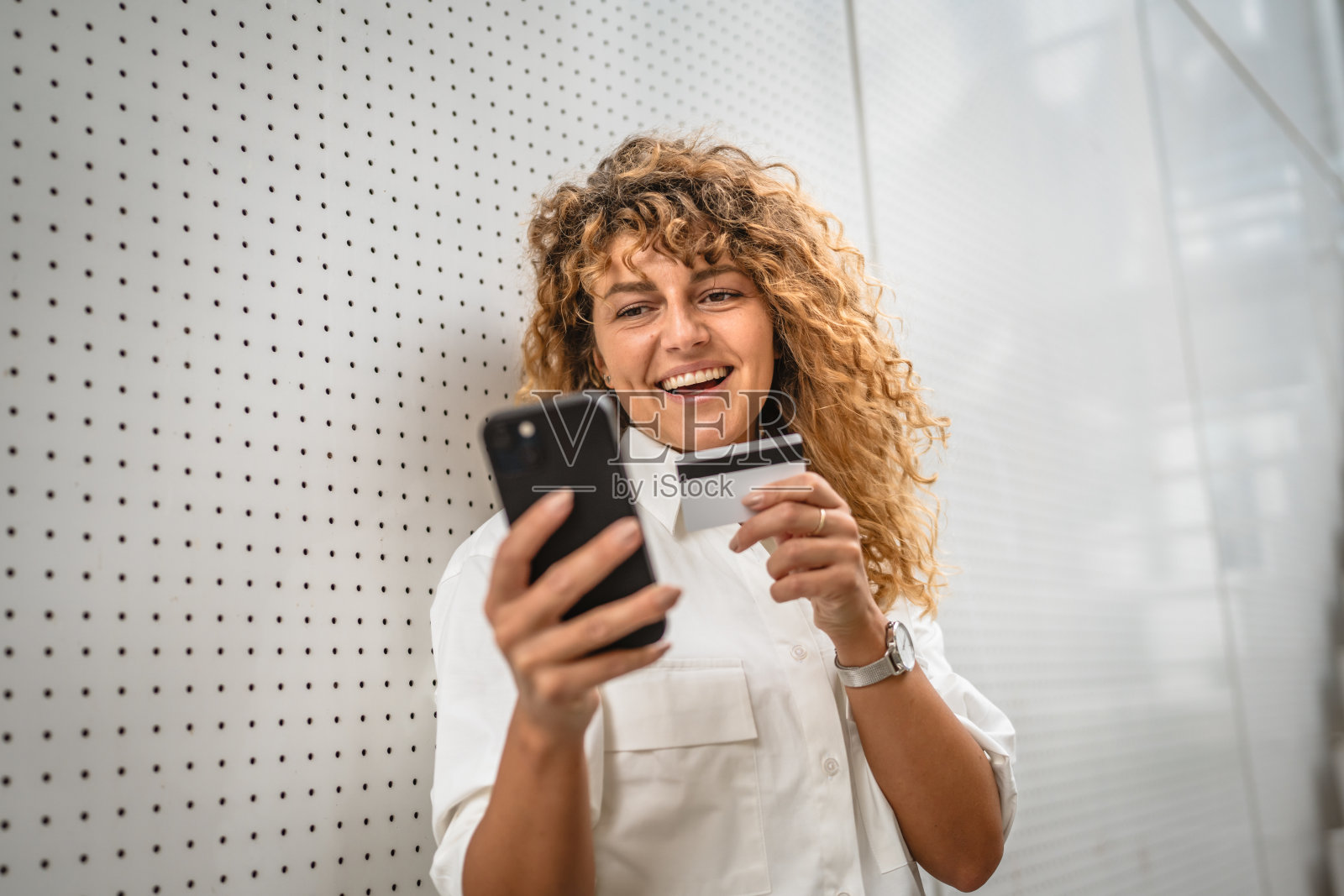 成年女性用信用卡站在手机上网购照片摄影图片
