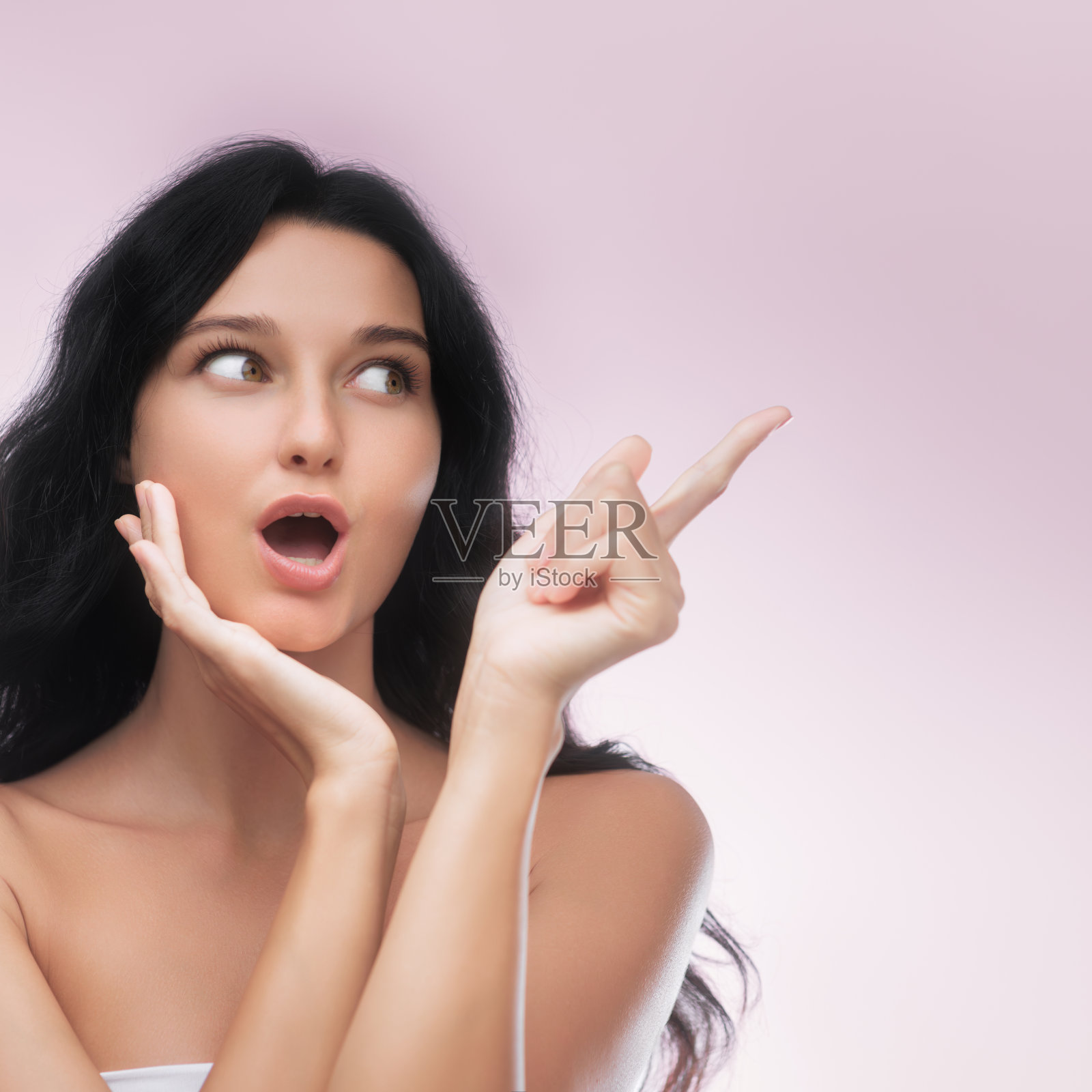 在工作室的特写肖像中,惊讶的女人兴奋地向上指着照片摄影图片