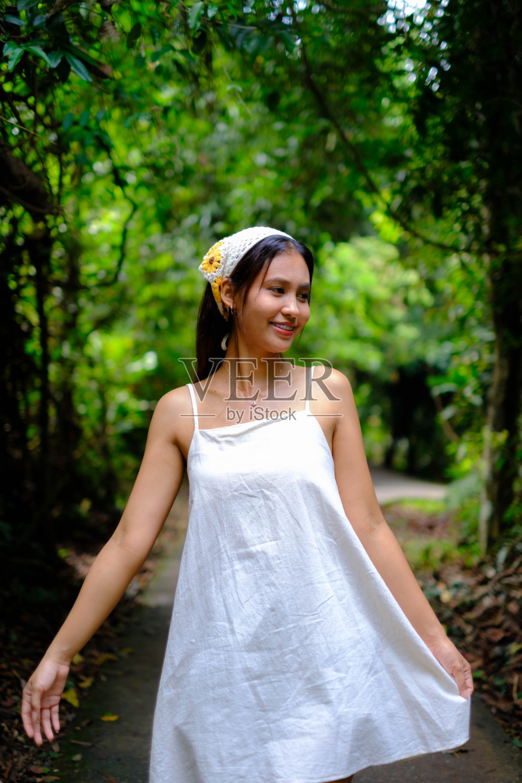 一位年轻的亚洲女子欣赏一棵树。照片摄影图片