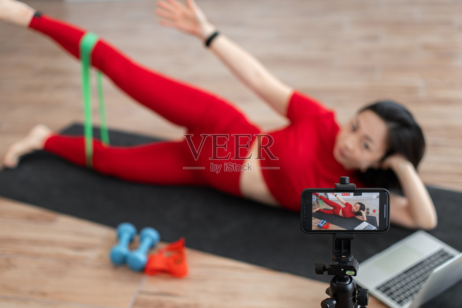 女子在网上健身课上用阻力带锻炼照片摄影图片