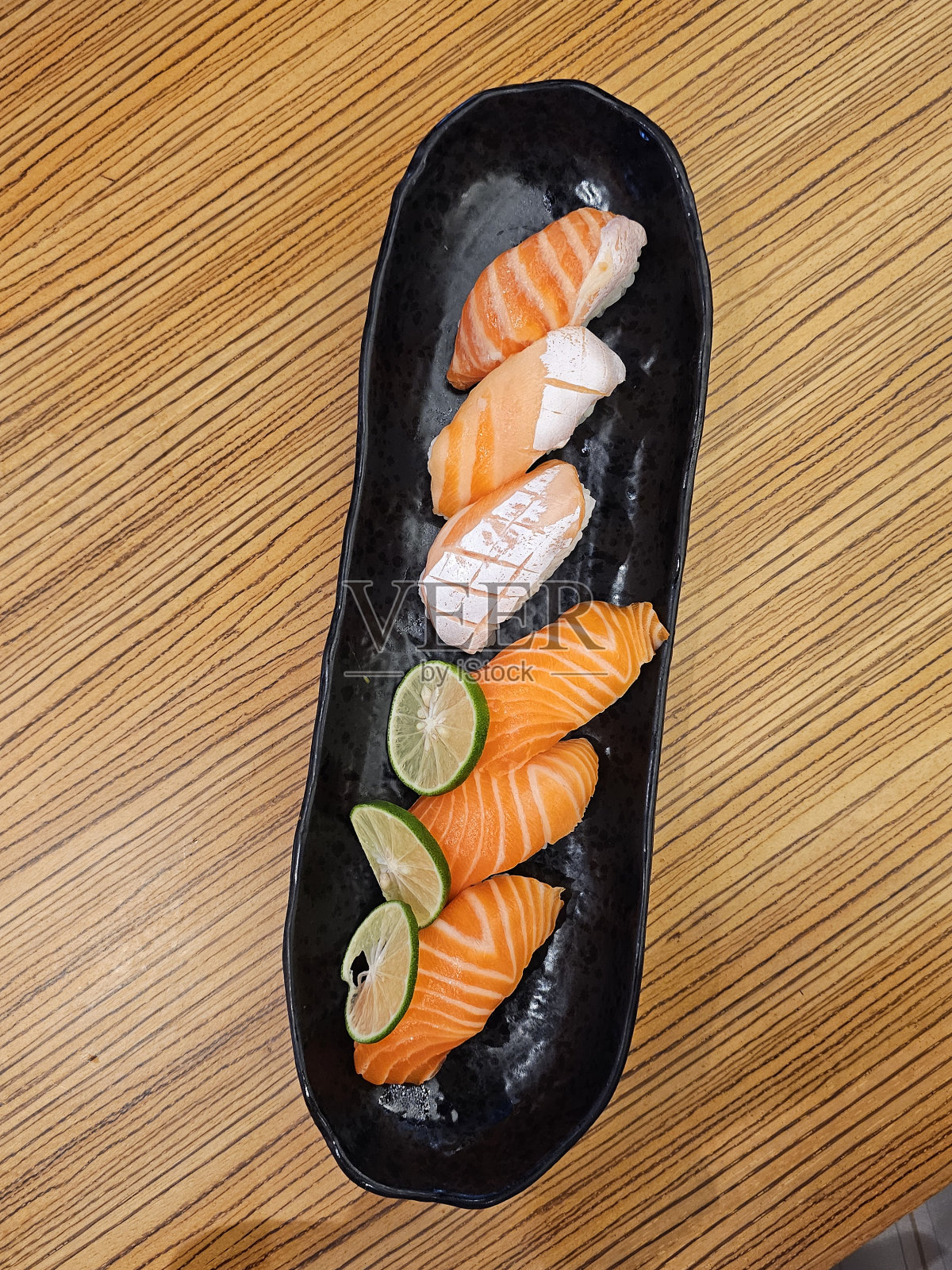 寿司店的木桌三文鱼寿司。照片摄影图片