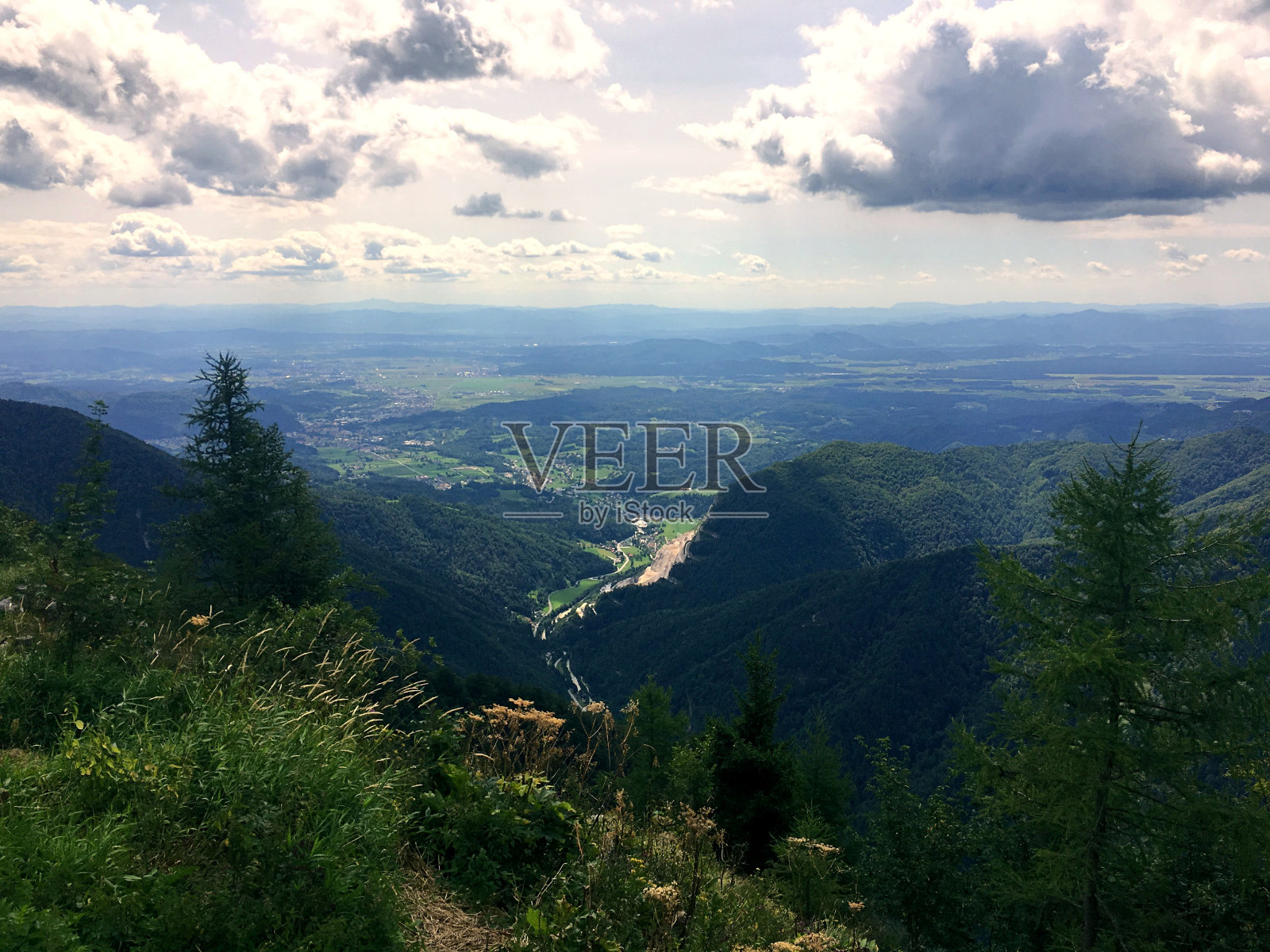 在一个阳光明媚的日子里,从山顶俯瞰山谷全景照片摄影图片