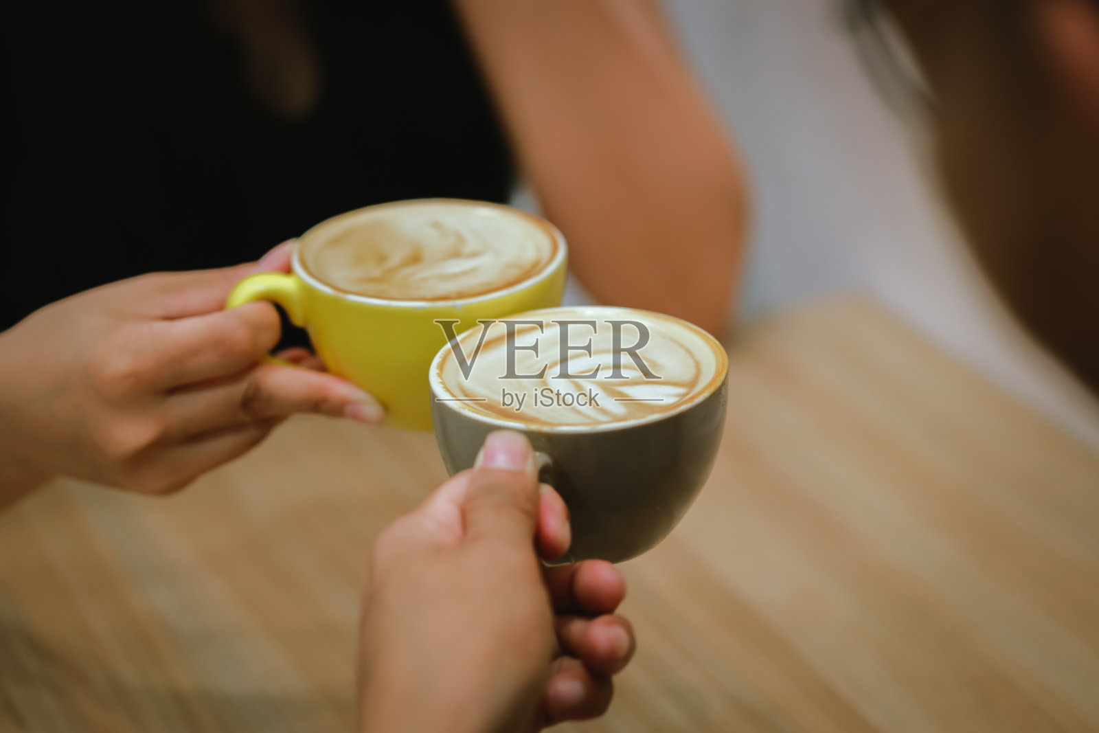 亚洲男人和女人,在咖啡馆享受早上的会议,拿着一杯热拿铁,在一个愉快,轻松的氛围中,背景模糊。照片摄影图片