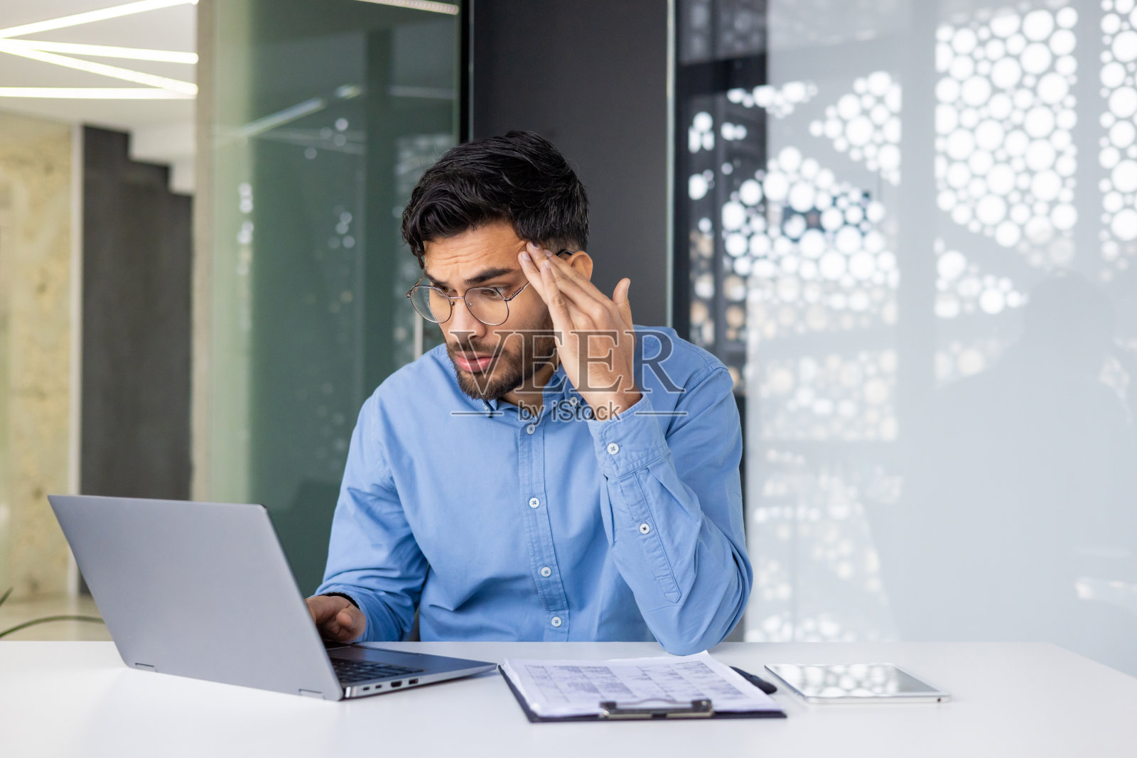 在现代办公室使用笔记本电脑工作的年轻专业人士照片摄影图片