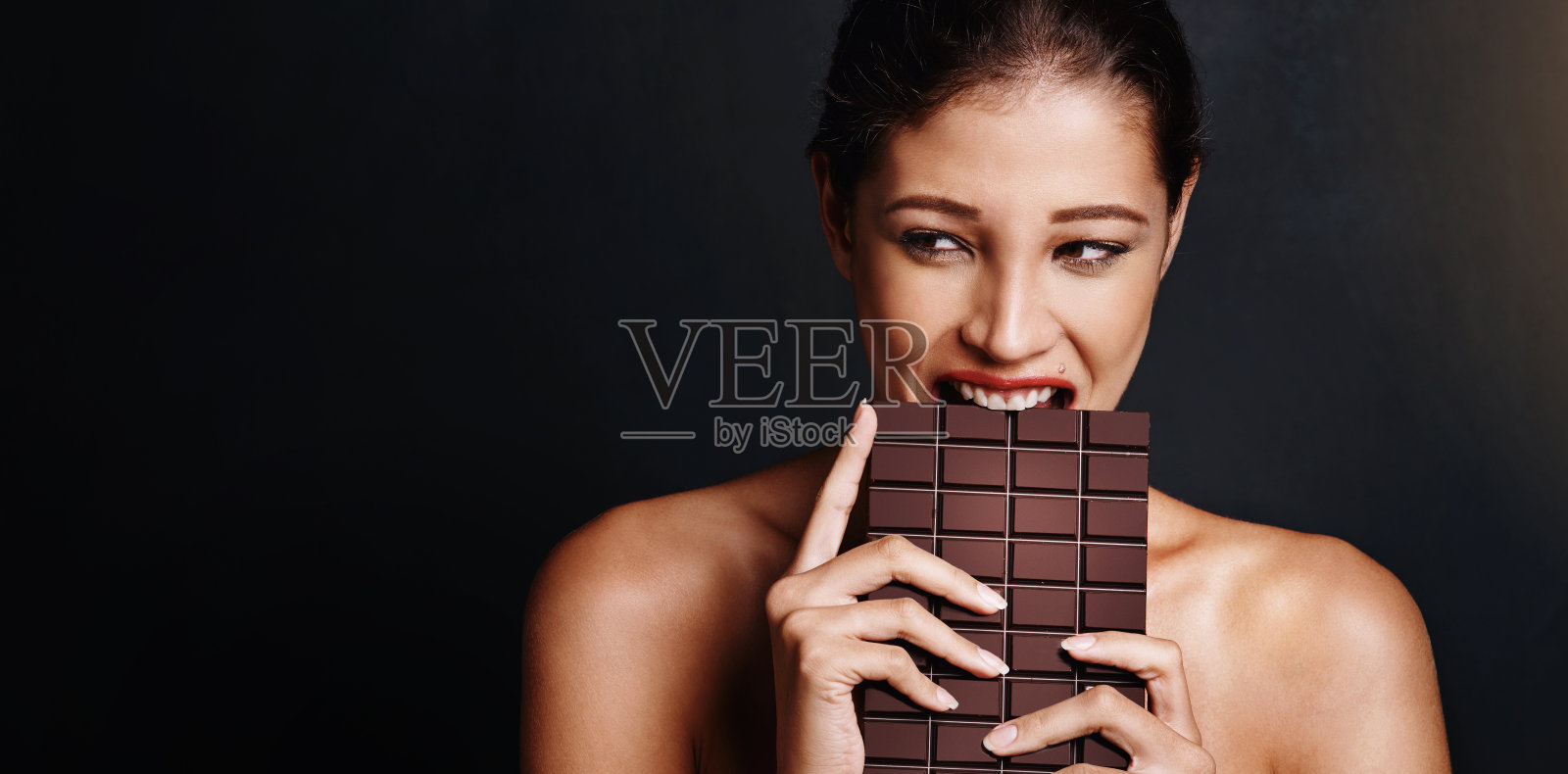 女人,吃着巧克力和工作室里的空间,黑色背景下的思考,选择和美丽。人,模型和快乐的咬或黑糖,可可或记忆与抗氧化剂的饮食照片摄影图片