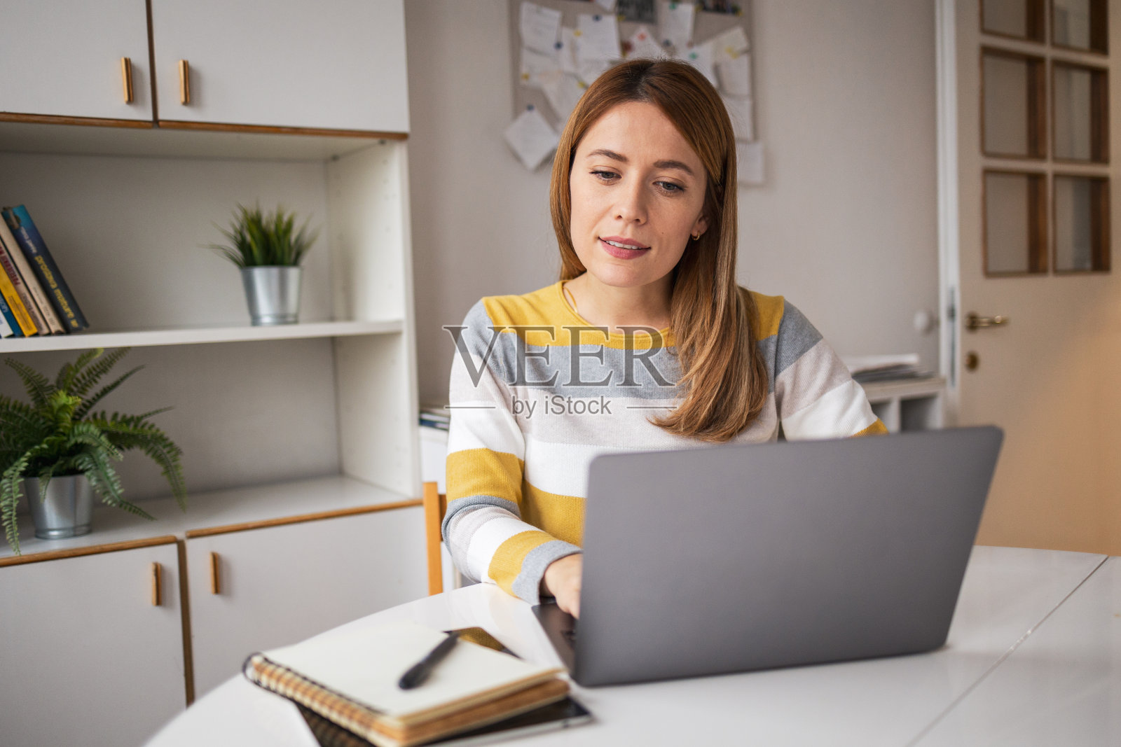 白种女性自由职业者在家办公室用上网本工作照片摄影图片