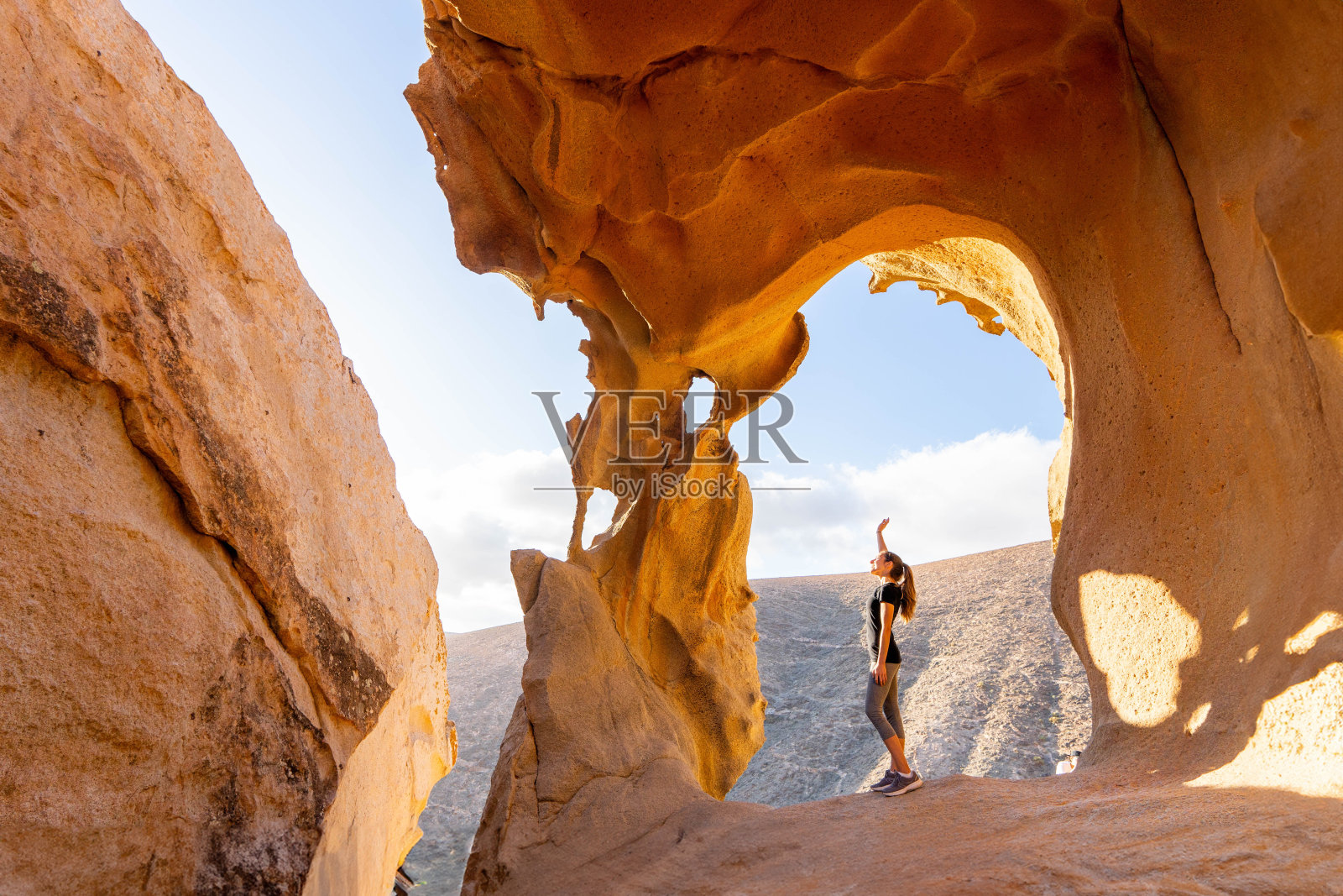冒险家在富埃特文图拉的日落时分探索Arco De Las Penitas照片摄影图片