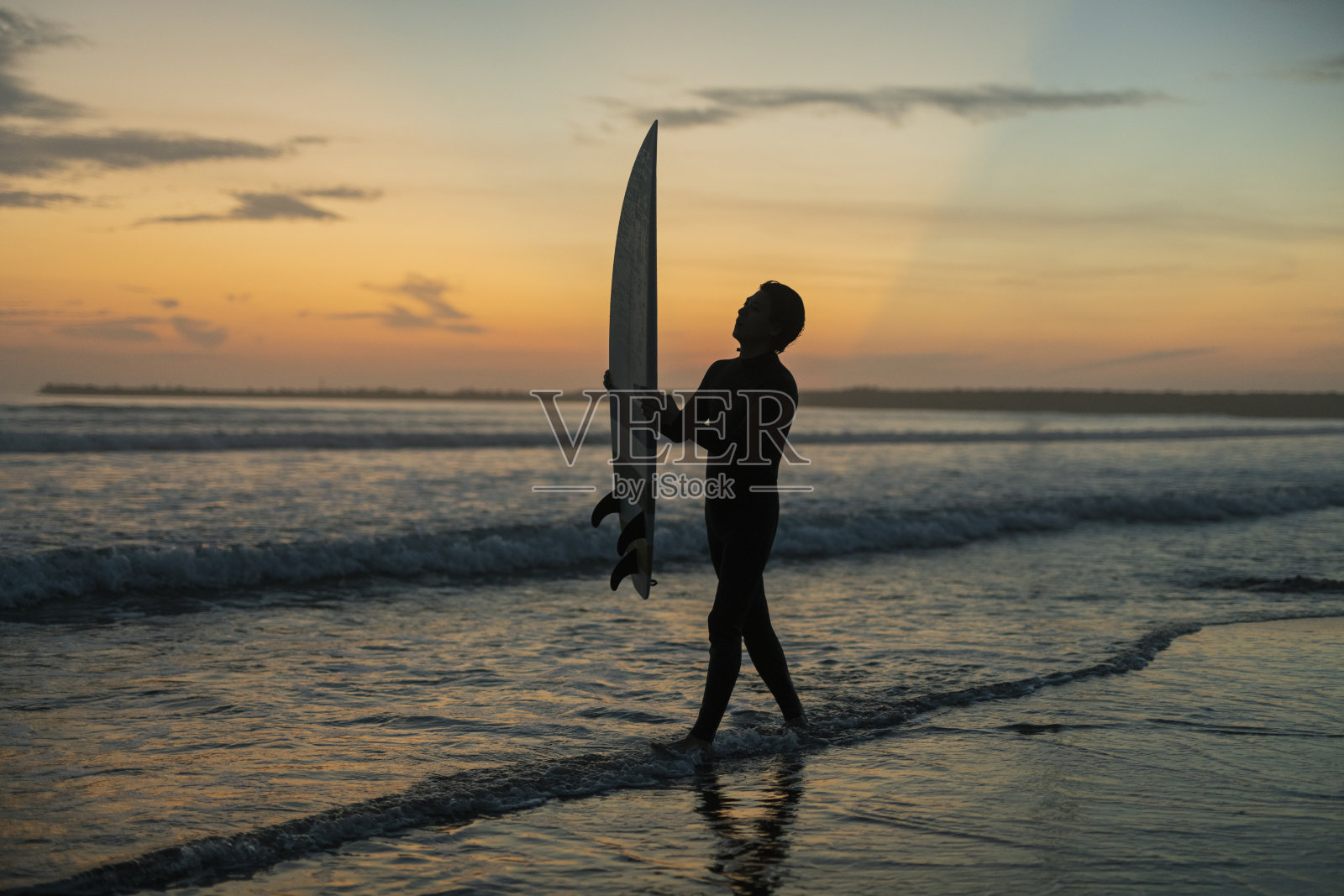 男子在清晨的海洋中冲浪。照片摄影图片