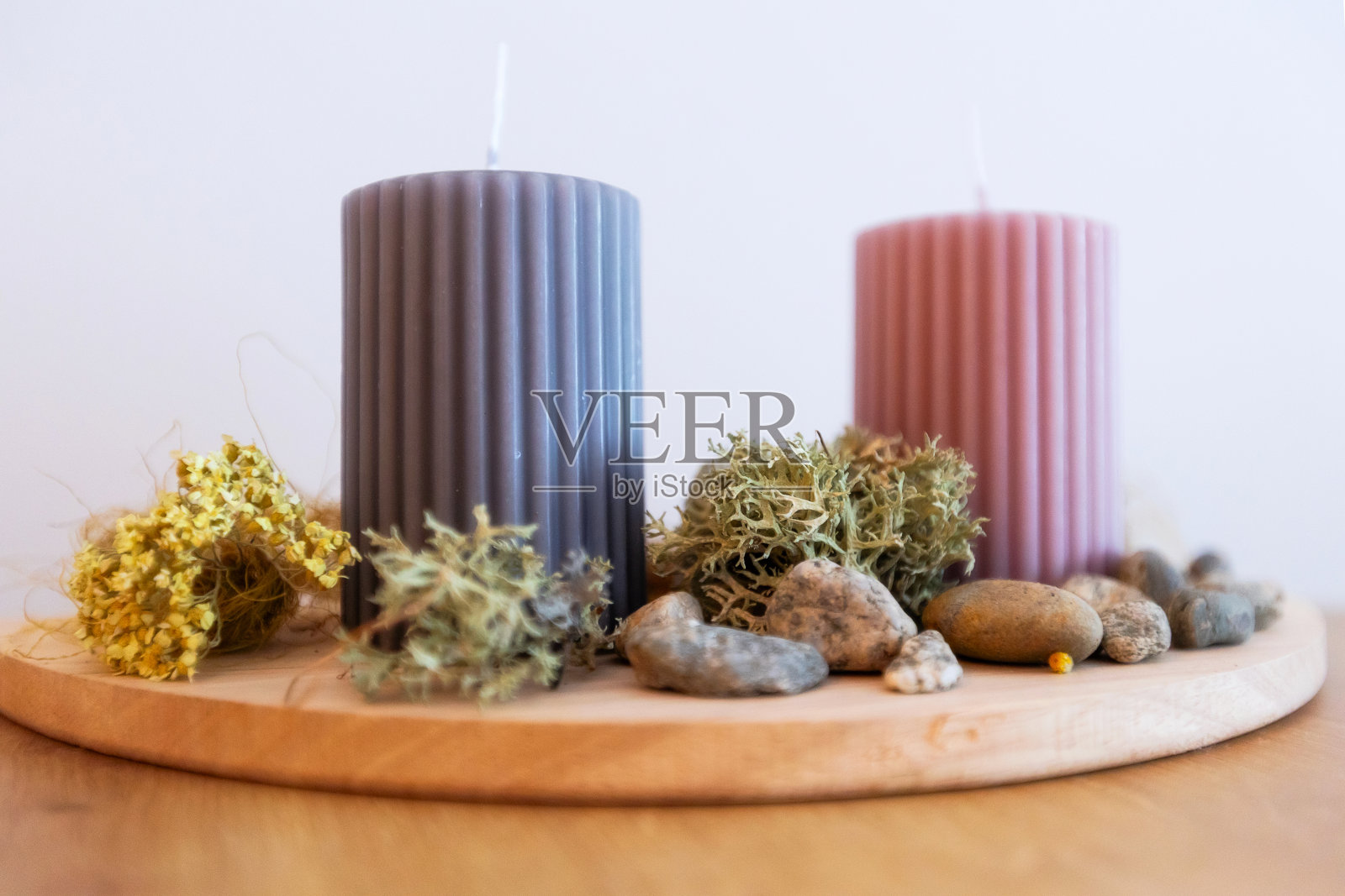 两支蜡烛在木架上,石头和苔藓照片摄影图片