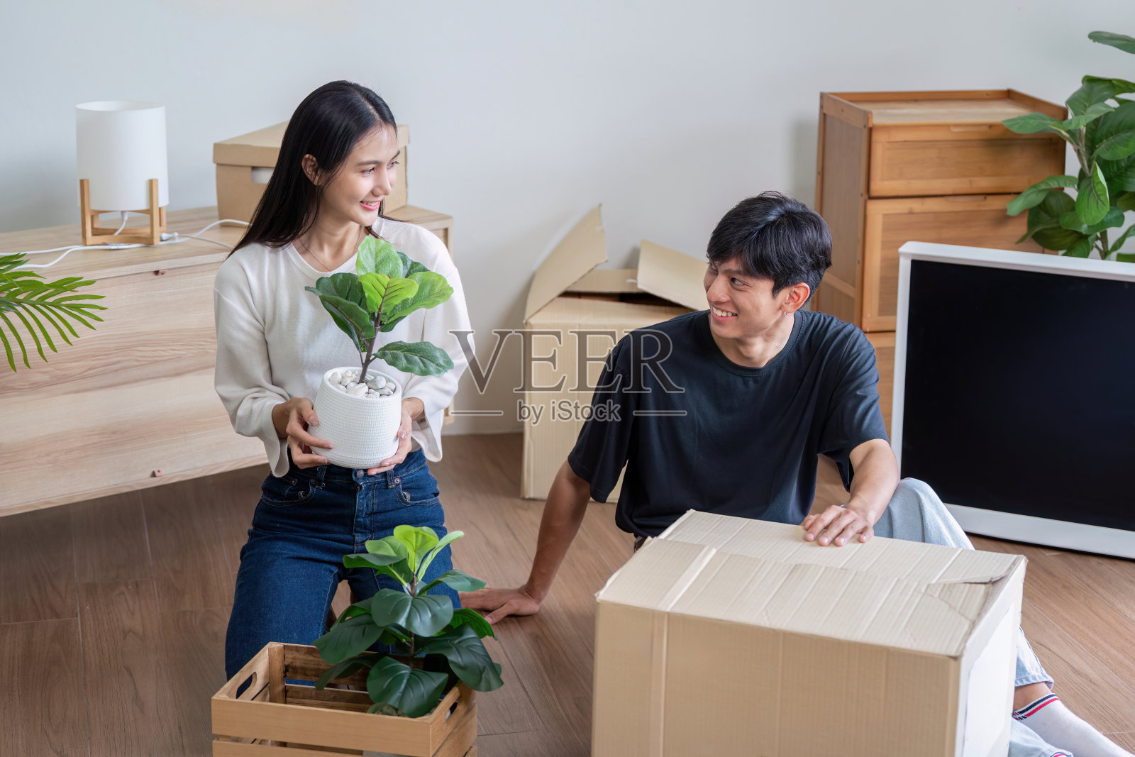 幸福的夫妇打开箱子,搬进新家,在现代生活空间中开始新的生活照片摄影图片