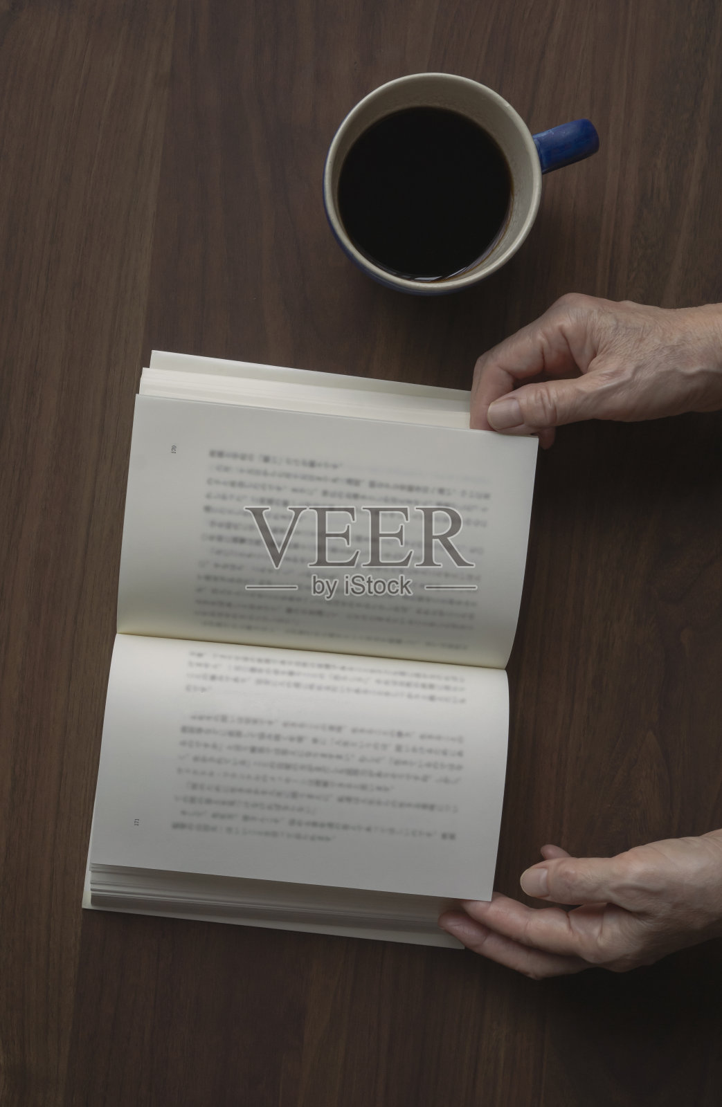 在读一本书的高年级女生。照片摄影图片