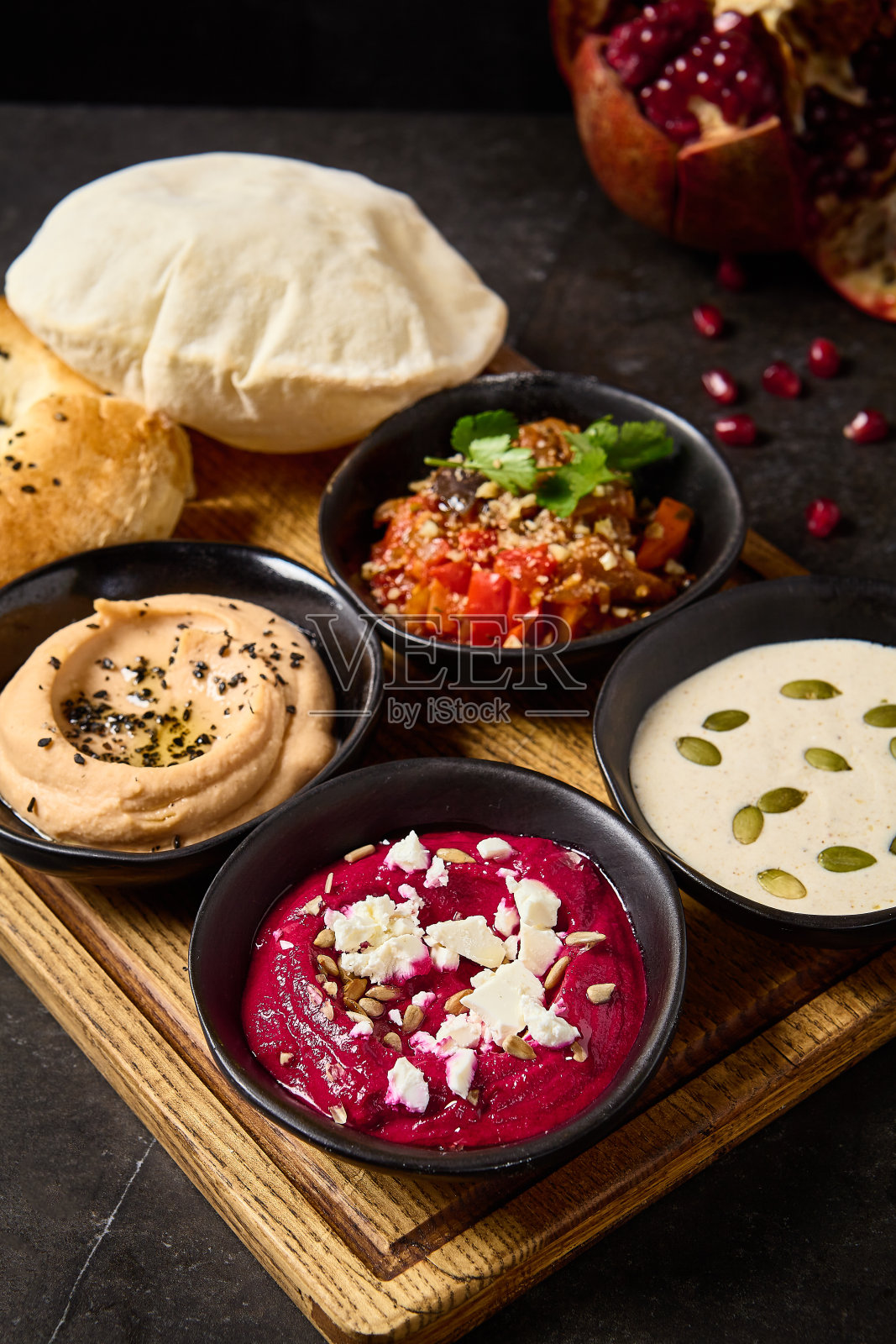 地中海美食拼盘配皮塔饼和面饼:鹰嘴豆泥,甜菜鹰嘴豆泥,阿扎普桑达和汤纳托沙司照片摄影图片