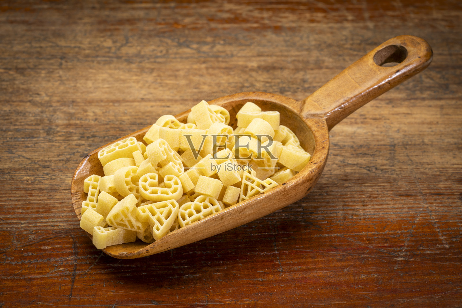 ABC 123手工意面在一个古老的木制勺对抗风化的木材照片摄影图片