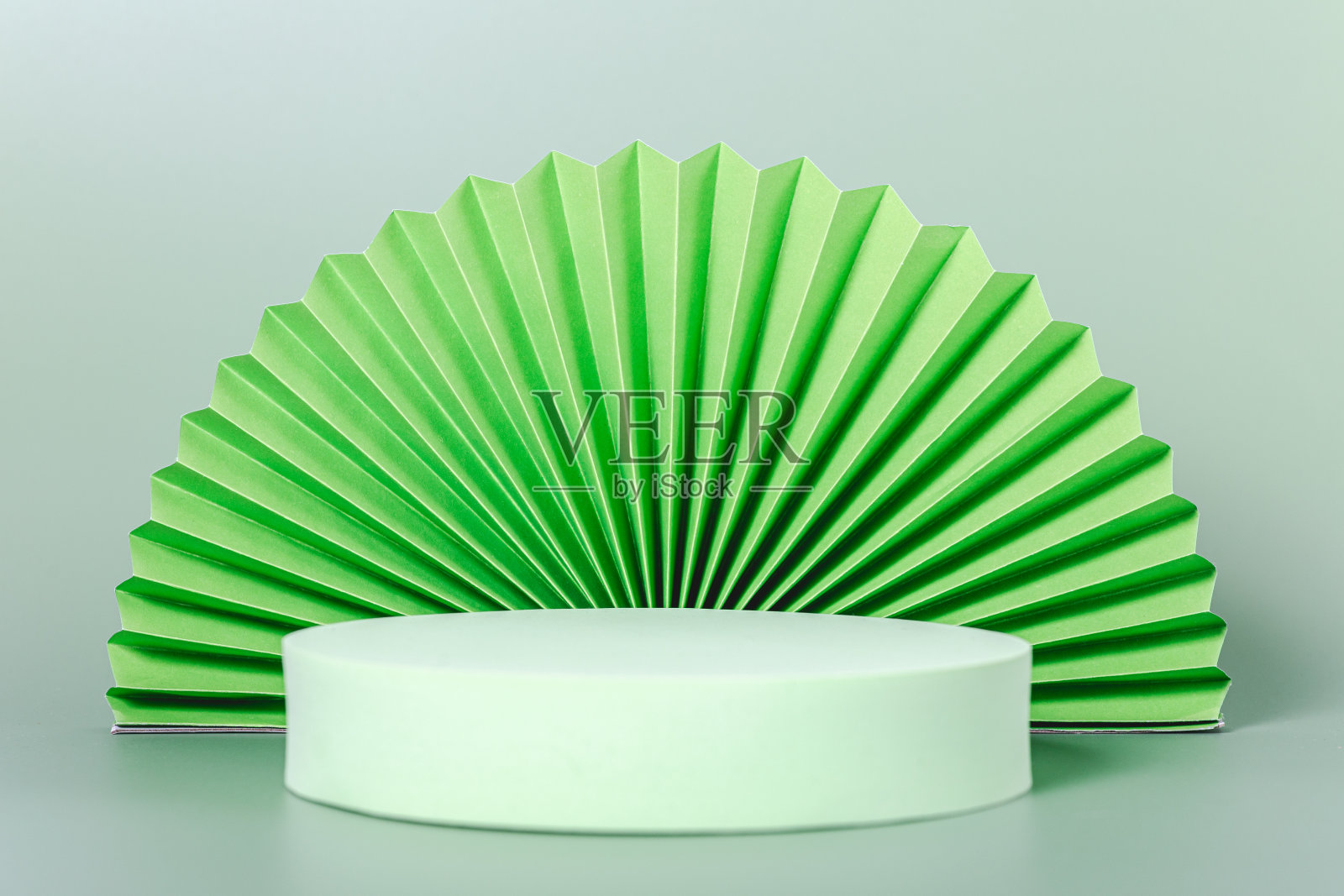 一个绿色的纸扇放在一个白色的底座上照片摄影图片