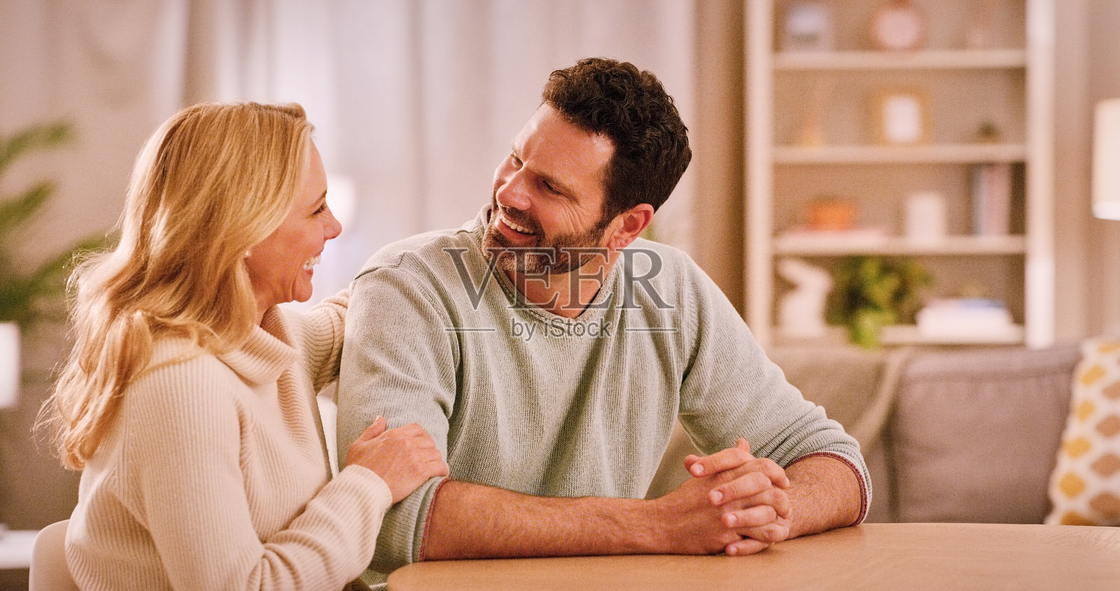 夫妇,爱和放松在家里与笑声,桌子和谈话在客厅建立联系。关系,团结和支持的伙伴与信任,男人和女人的婚姻和谈话的人照片摄影图片