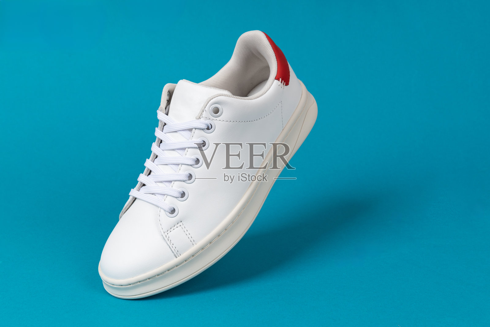 蓝色背景的运动鞋。运动鞋或运动鞋。白色的鞋。健身、运动、训练理念。照片摄影图片