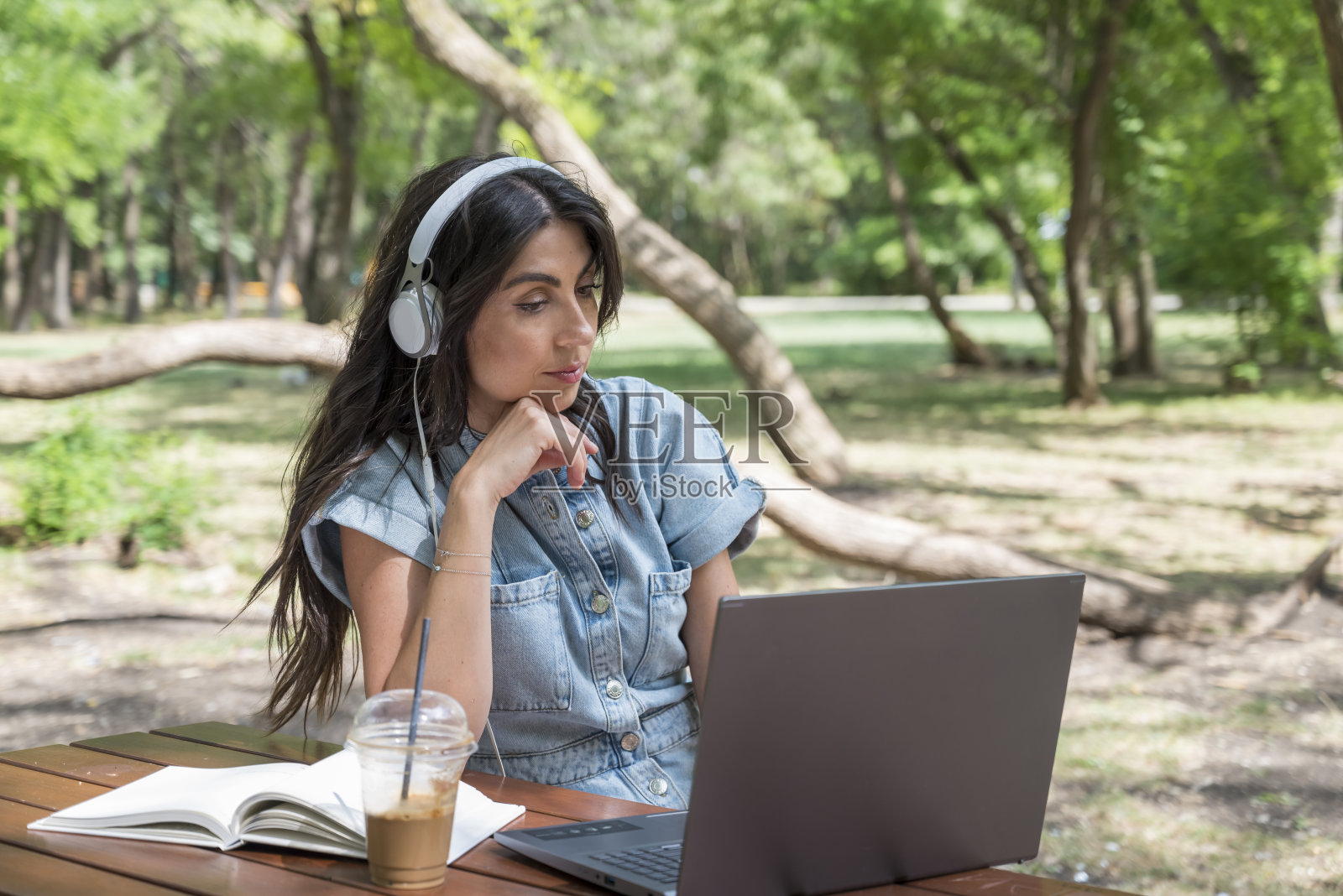 坐在公园里摆弄笔记本电脑的女人照片摄影图片