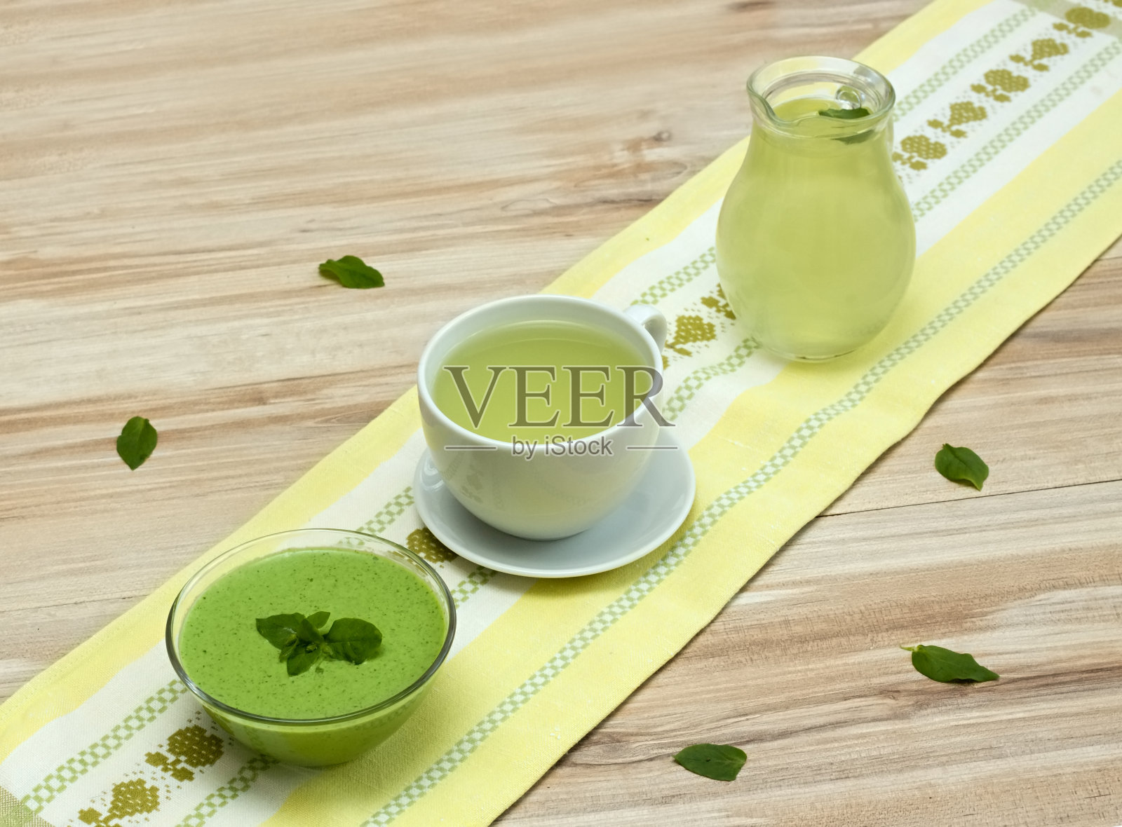 一杯和一罐新鲜的茶,一碗从鹰嘴豆来的冰沙。桌上有紫花菌培养基。照片摄影图片