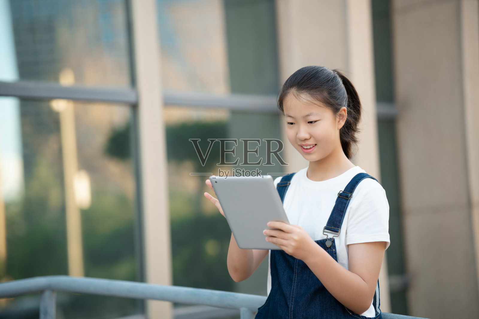 十几岁的女孩在中学校园里使用数码平板电脑照片摄影图片