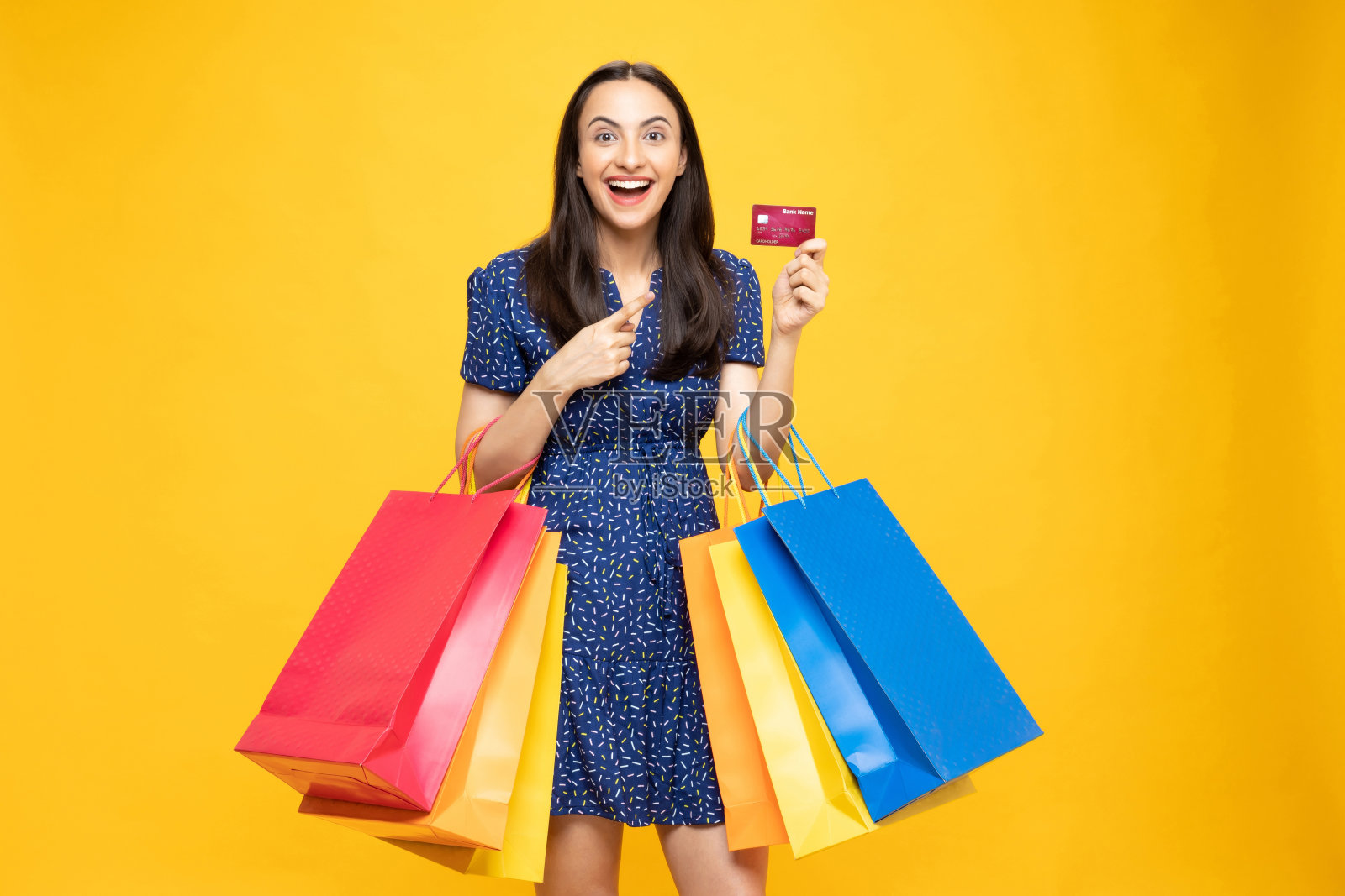 购物的照片欢快的女孩手里拿着彩色的袋子孤立在明亮生动的亮黄色背景股票照片照片摄影图片