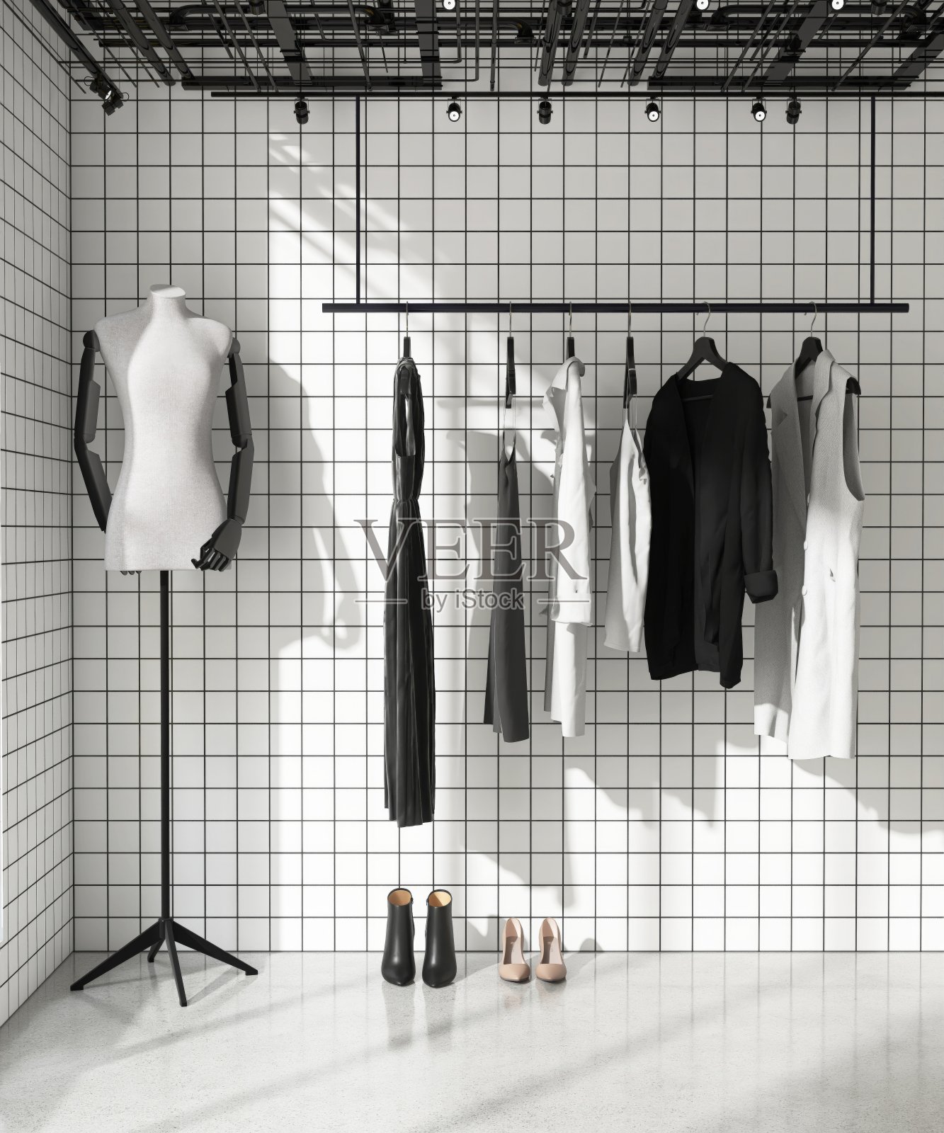 黑色和灰色的衣服在现代店铺展示用白色的方形瓷砖墙,黑色的灌浆线照片摄影图片