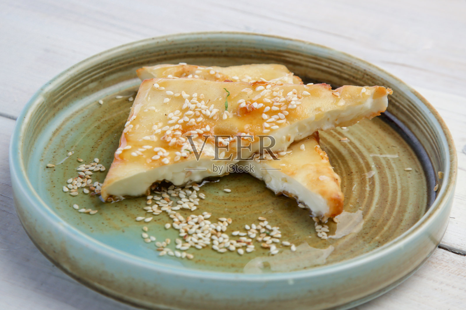 希腊炸羊乳酪加蜂蜜和芝麻照片摄影图片