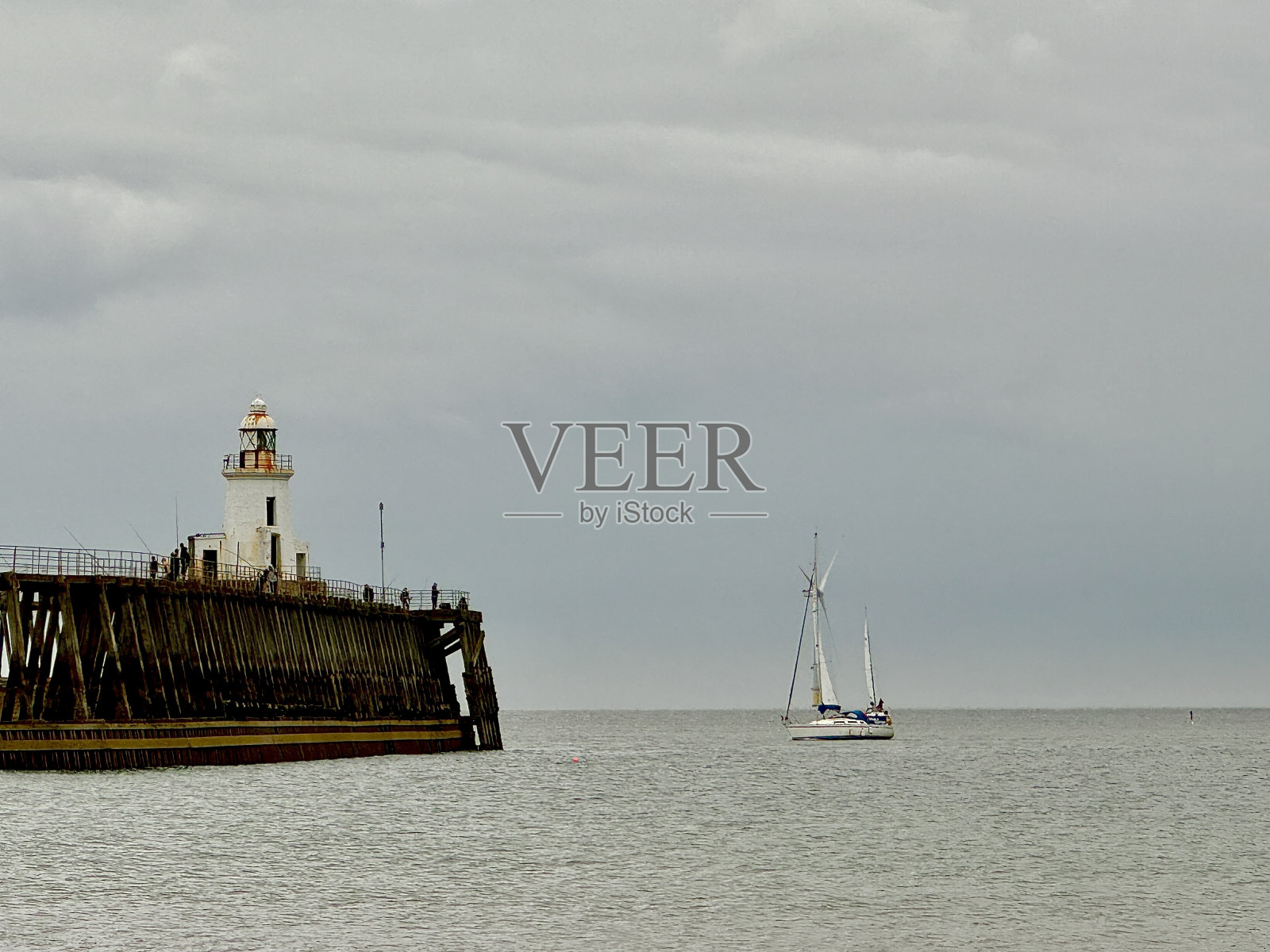 布莱斯码头和灯塔在诺森伯兰郡与小船接近港口照片摄影图片