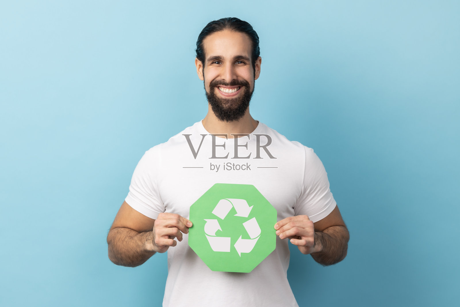 男人展示绿色垃圾回收标志,对环境安全感到满意照片摄影图片