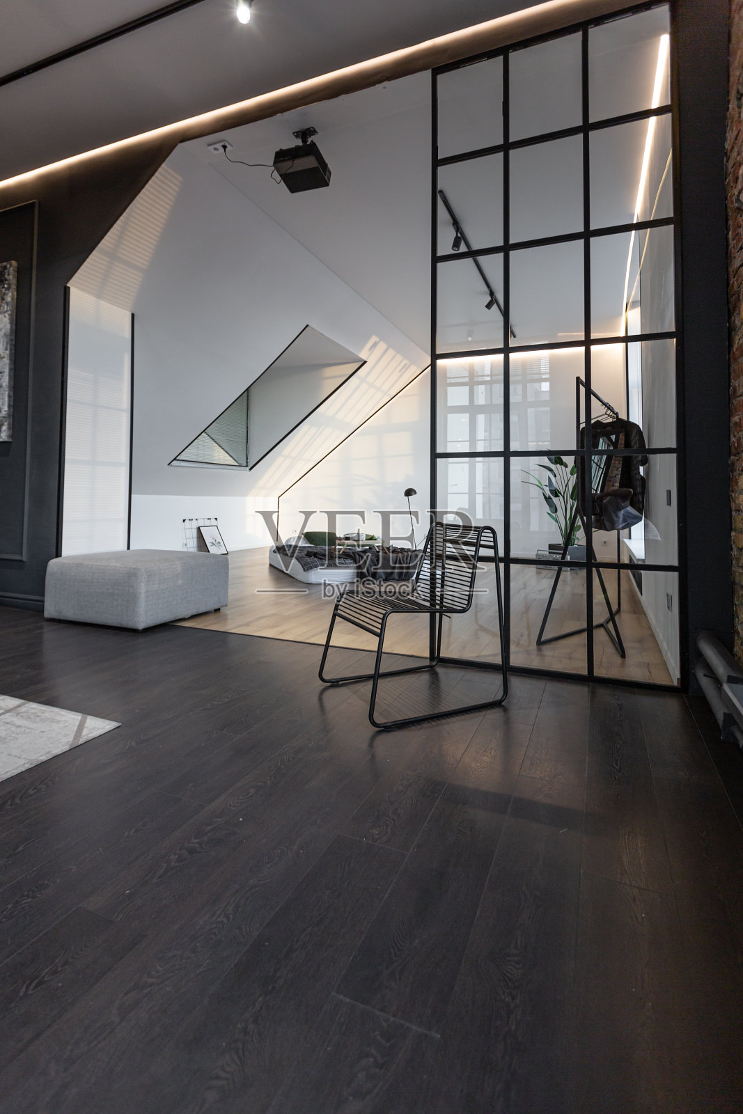 简约时尚的豪华公寓内饰,白色时尚的卧室和黑暗的客厅。现代公寓,白天开放式布局,没有人,阳光明媚照片摄影图片