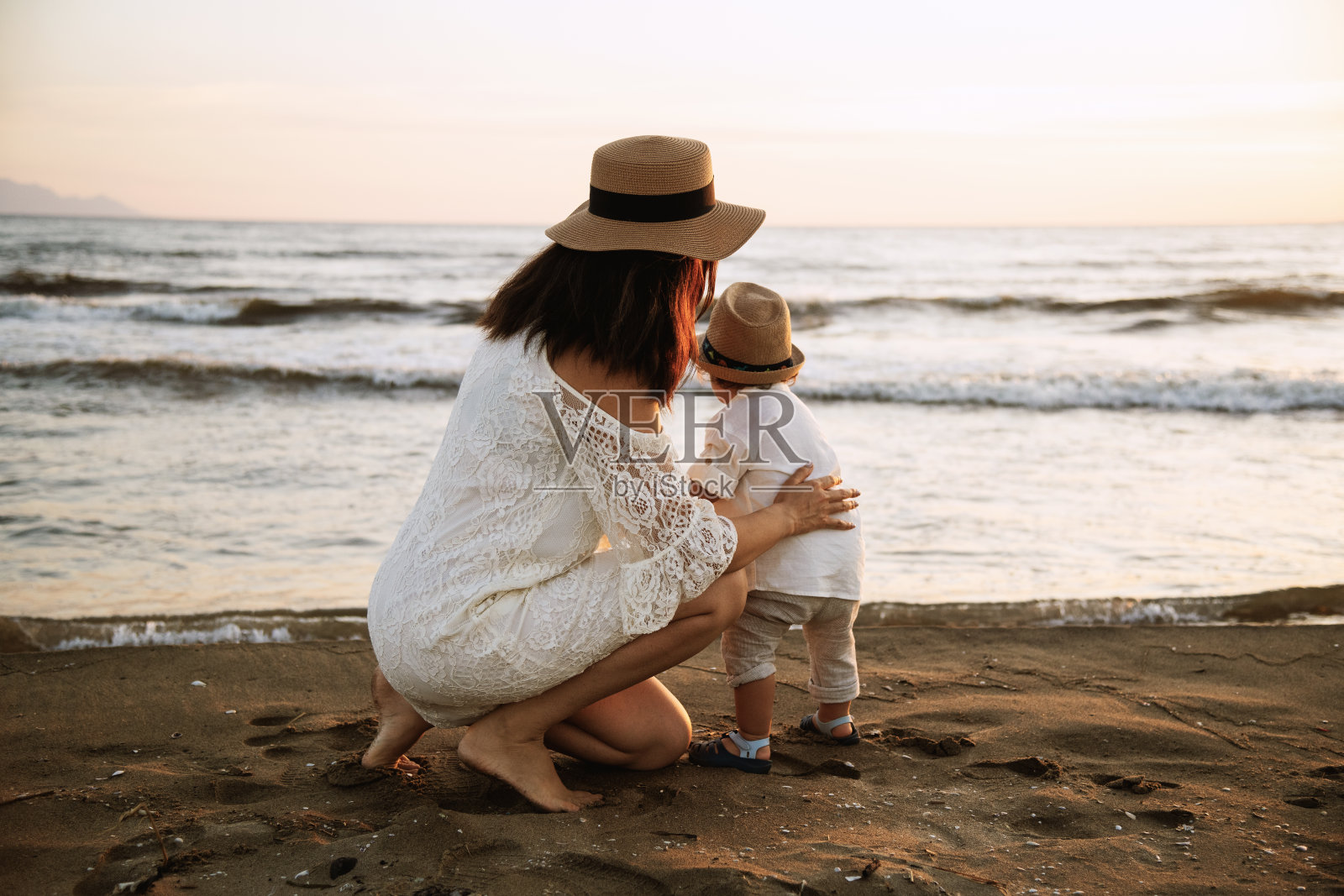 日落海滩上奔跑的母子照片摄影图片