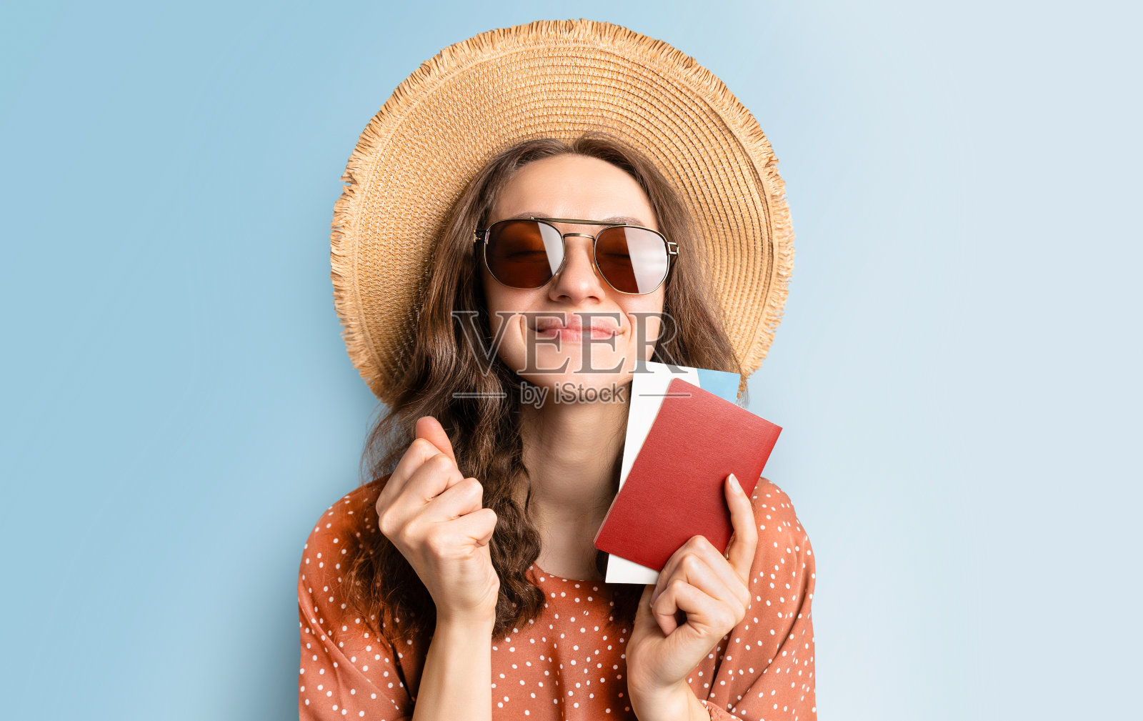 戴着遮阳帽,拿着护照和机票的快乐女人照片摄影图片