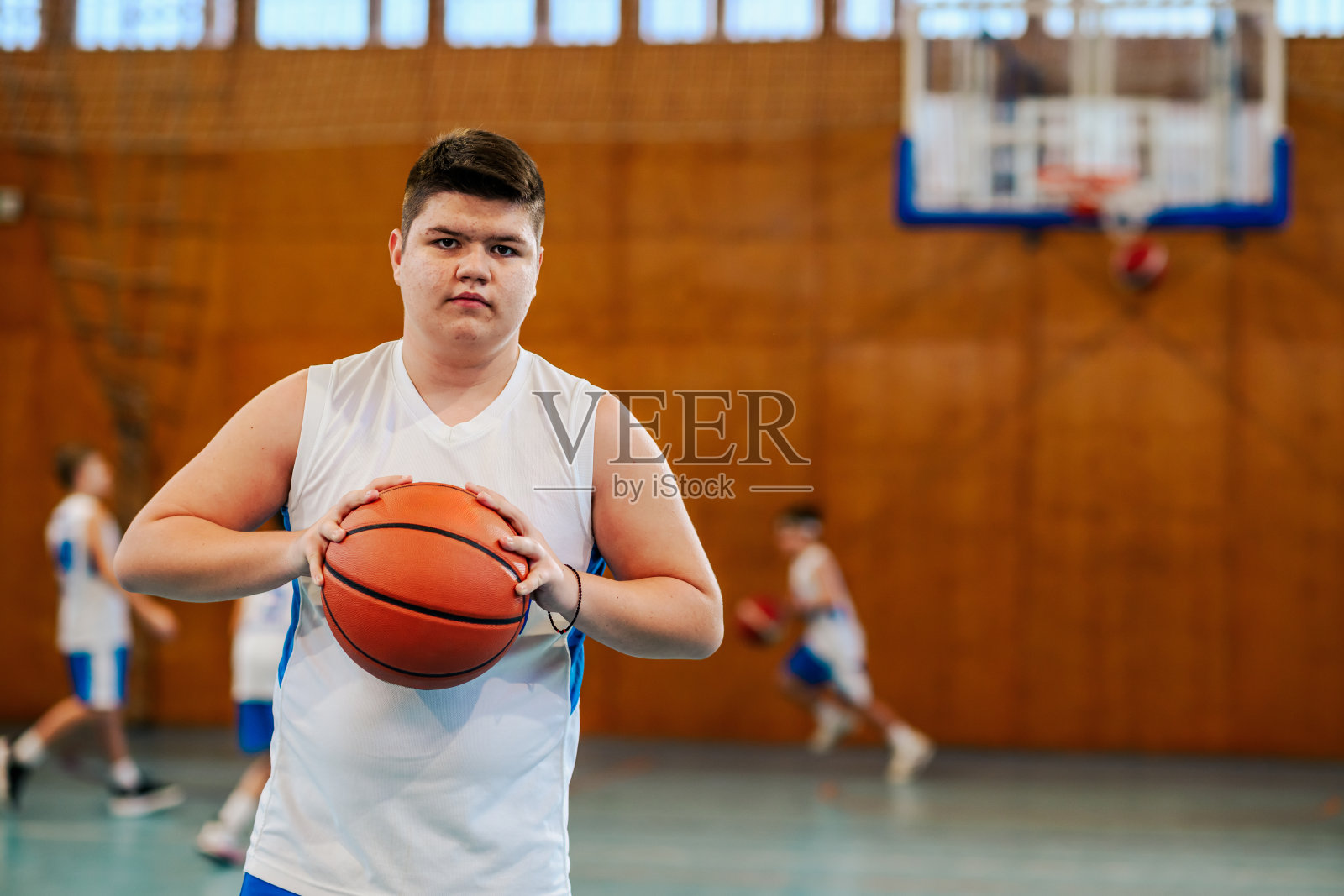 专注的孩子拿着篮球靠近照片摄影图片