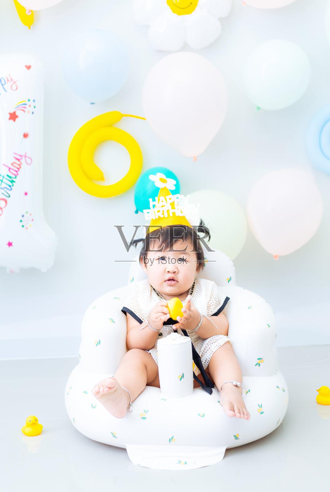 一个小女孩庆祝她的一岁生日。一个年轻的亚洲女孩庆祝她的第一个生日。照片摄影图片